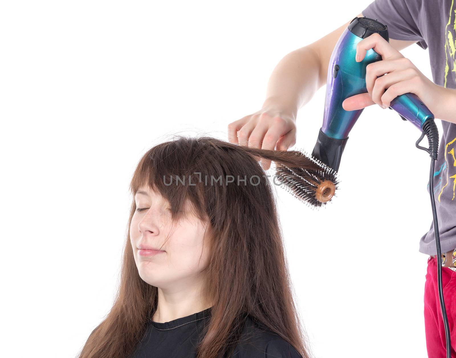 Woman enjoying having her hair blow dried, isolated on white