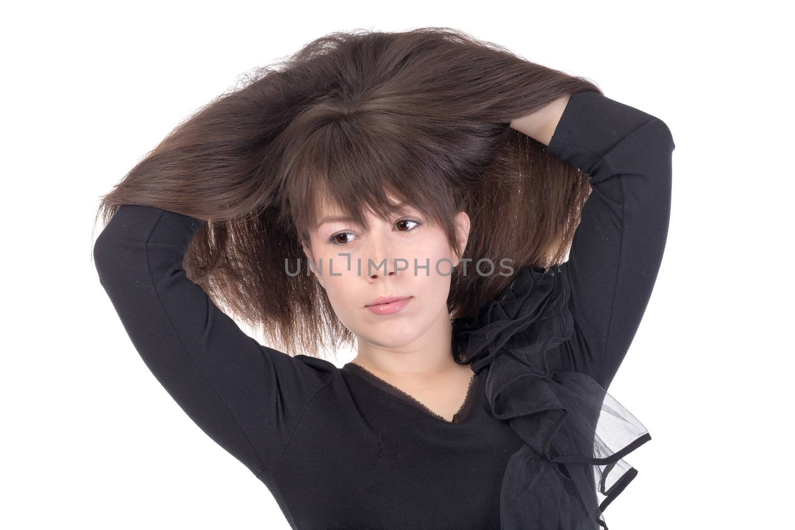 Attractive young woman with lovely long straight brunette hair running her hands through the tresses lifting them up above her head isolated on white