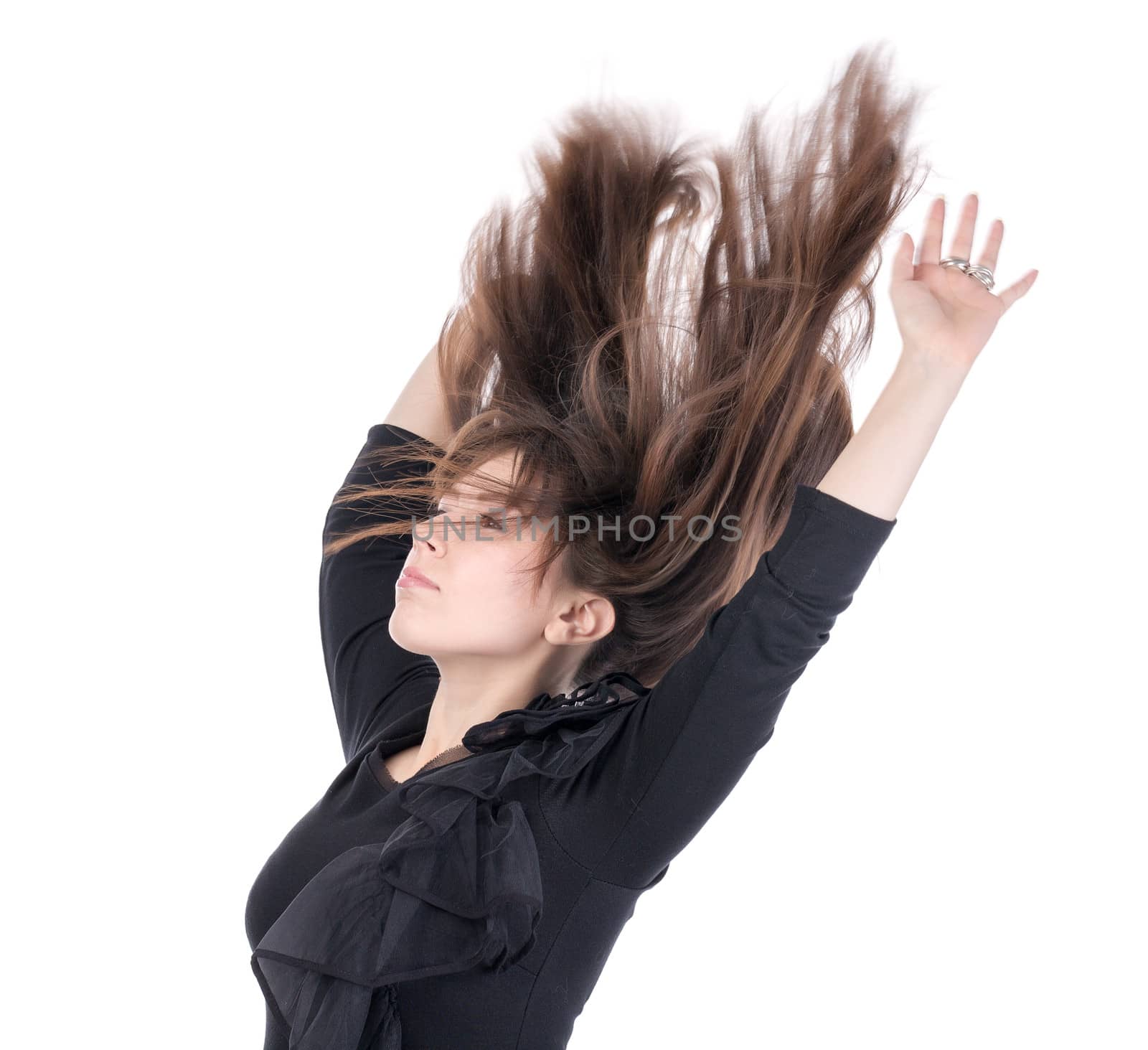 Young woman with her long straight brunette hair flying in the air and her arms raised above her head isolated on white