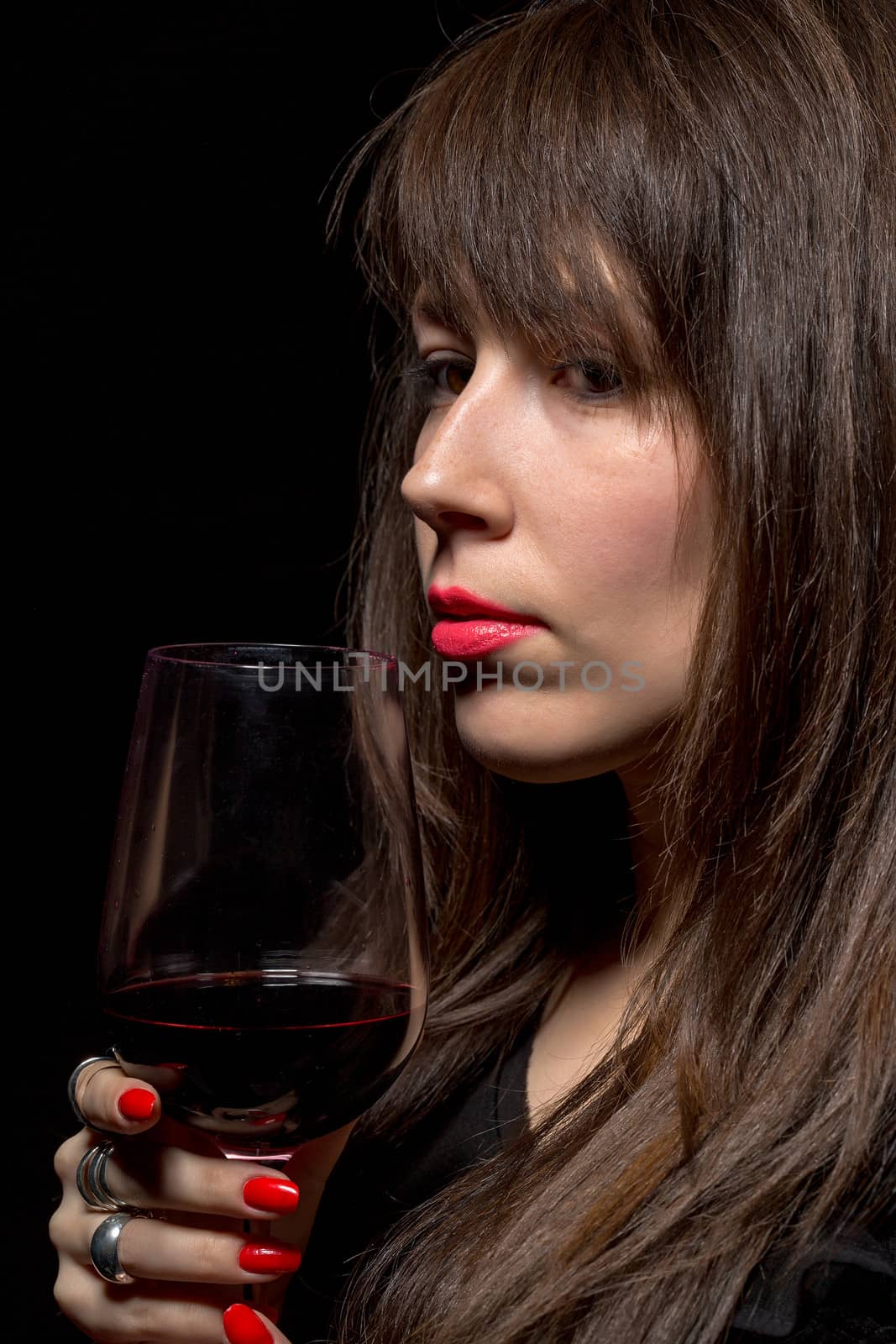 Young woman with red wine from a glass, closeup