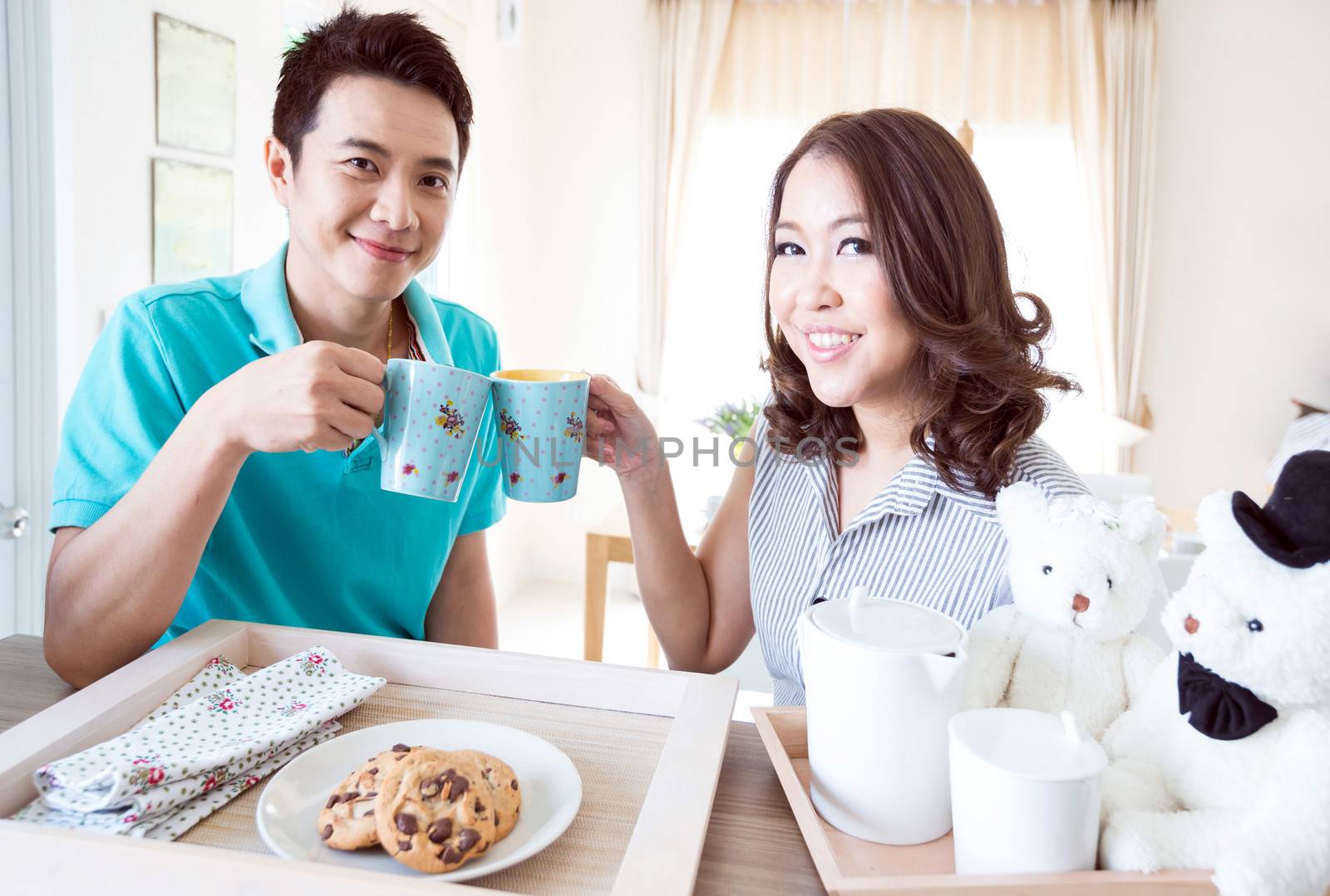 Young happy couple in domestic kitchen with breakfast