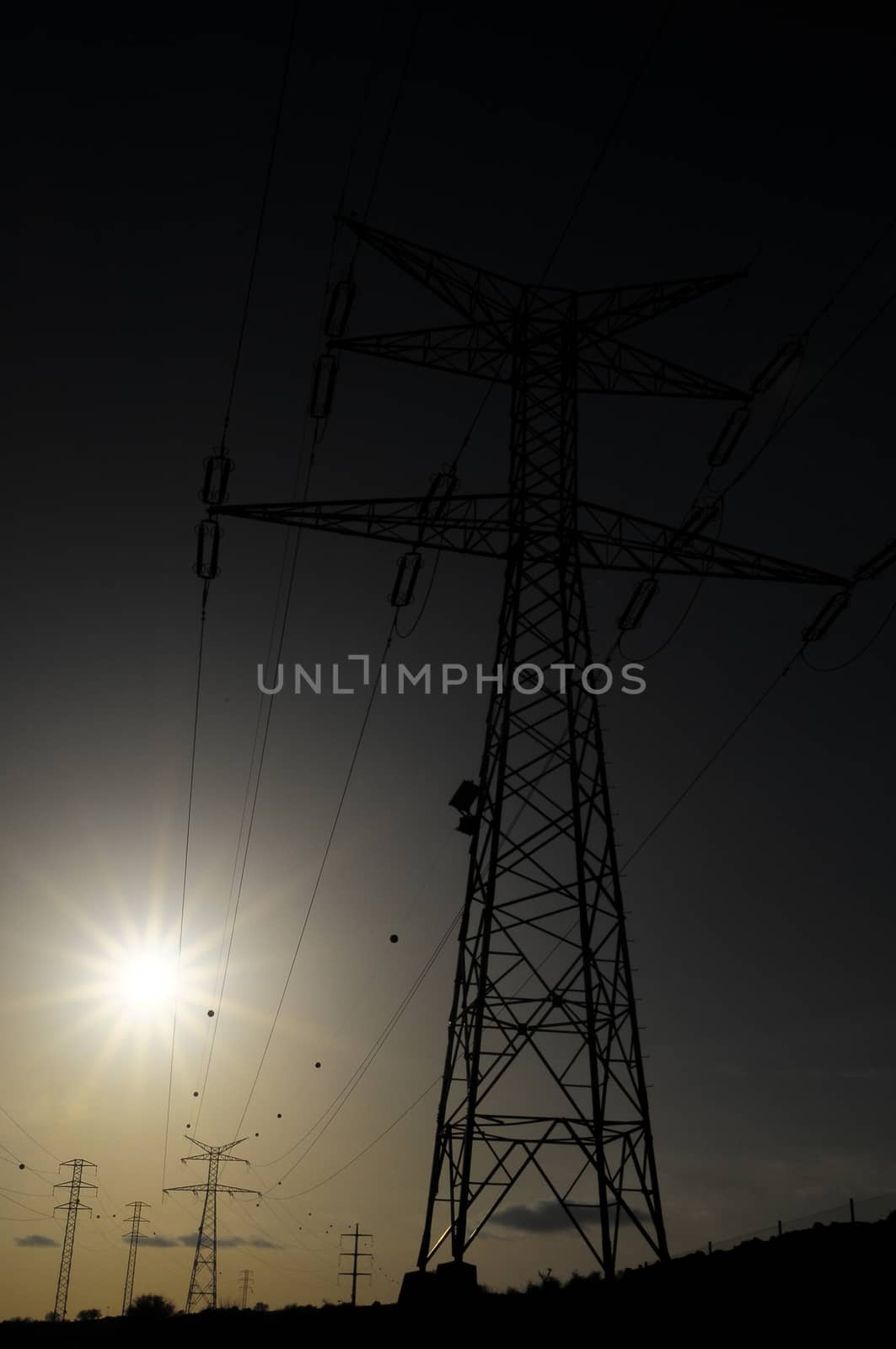 Electric Power Line Pylon over a colored Sunset