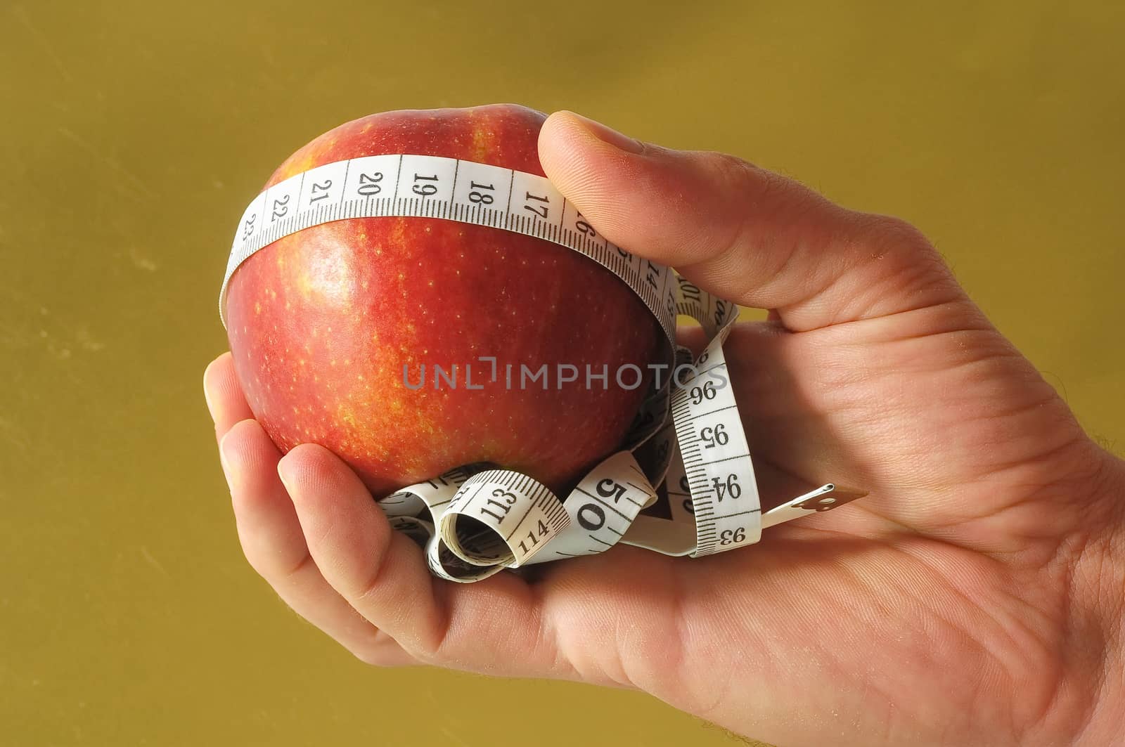 Diet Apple and Meter on the Hand on a Colored Background 