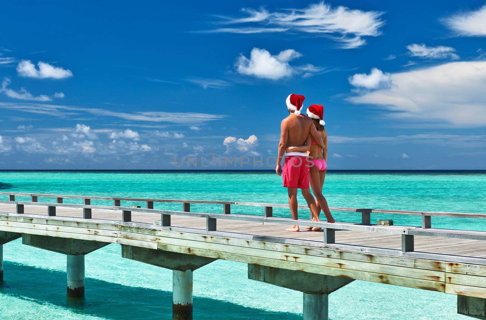 Couple on a tropical beach jetty at Maldives