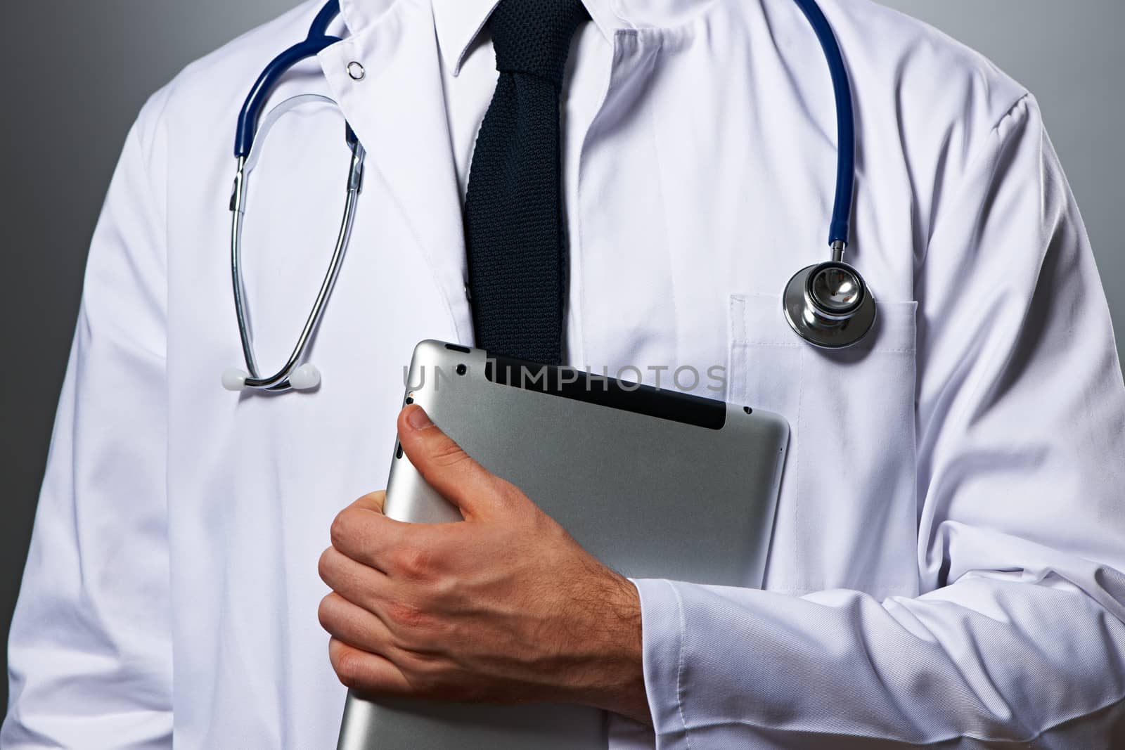 Medical doctor with tablet pc portrait against grey background 