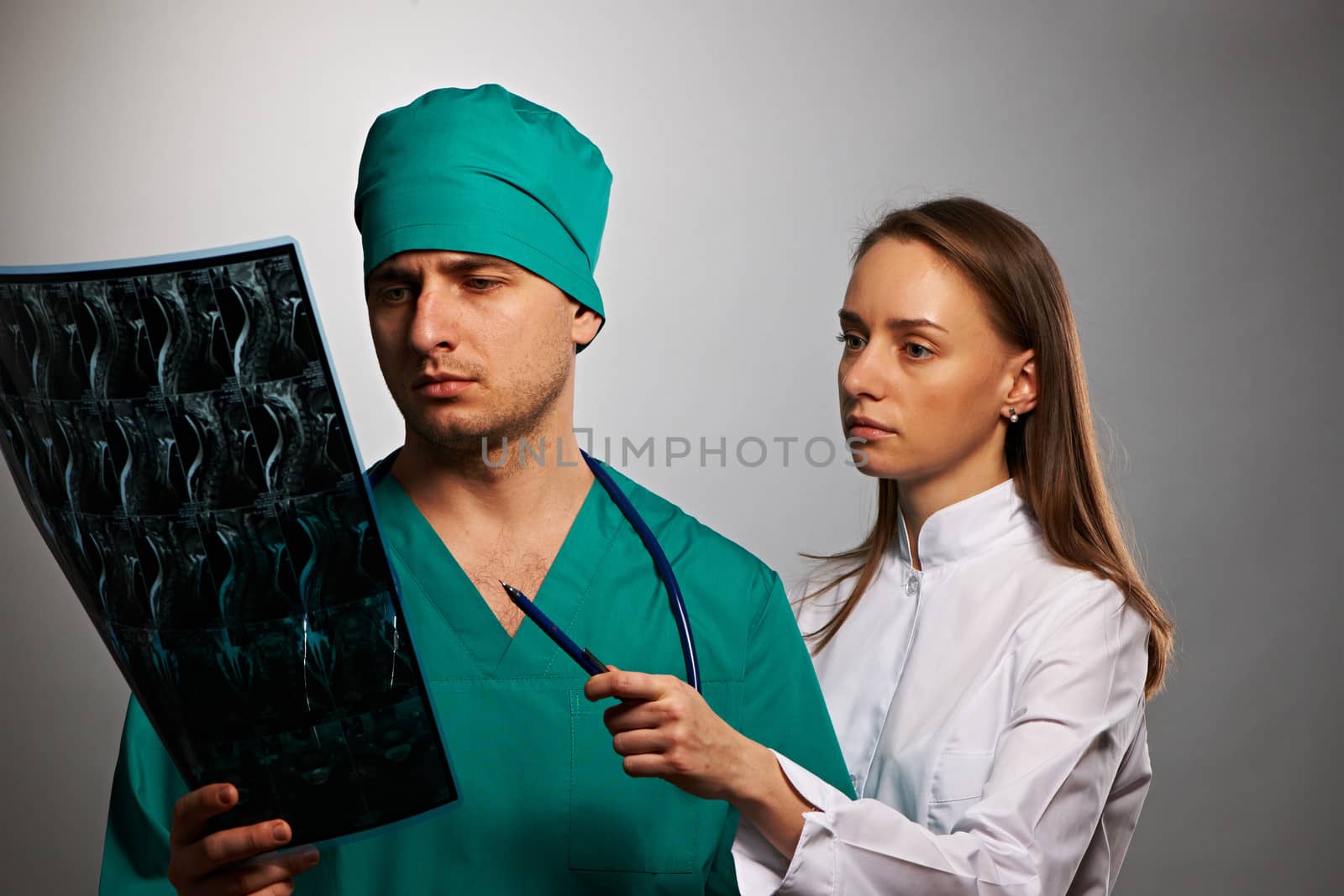 Medical doctors team with MRI spinal scan portrait against grey background 