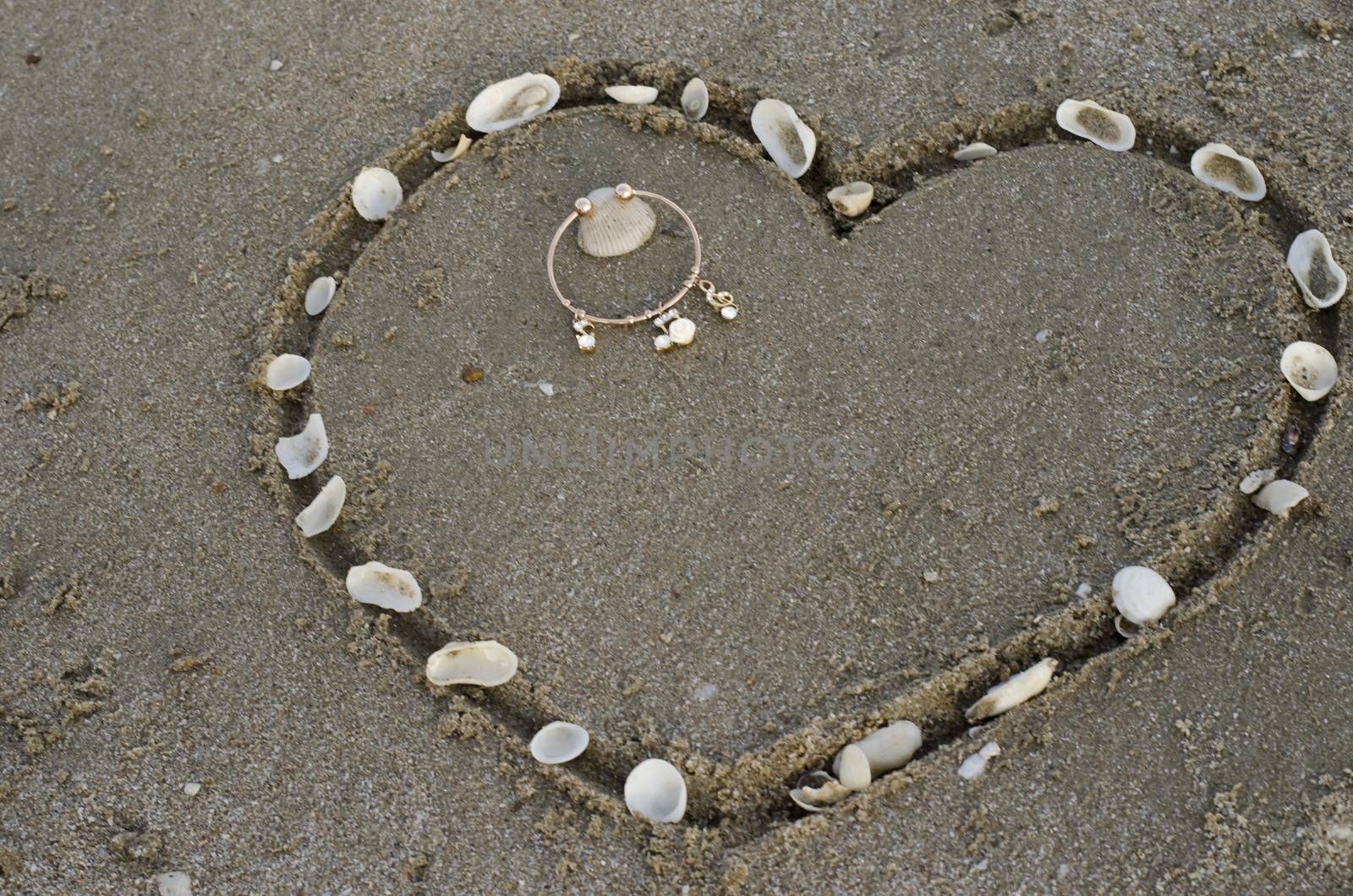 drawing heart on the sand in the beach