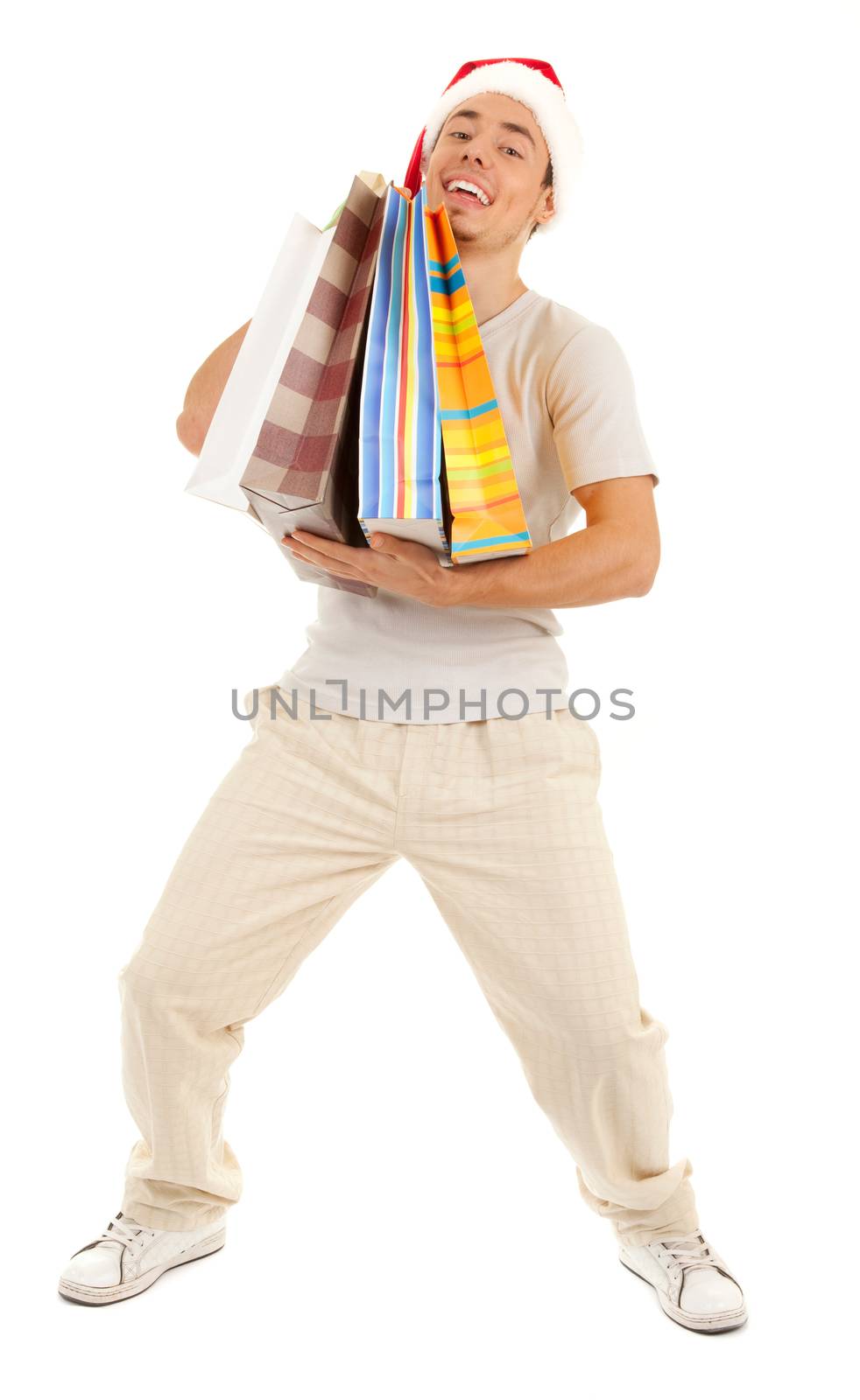 Young Santa with heavy purchases in paper bags on white background