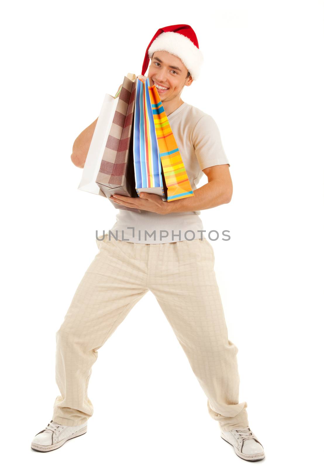 Young Santa with heavy purchases in paper bags on white background