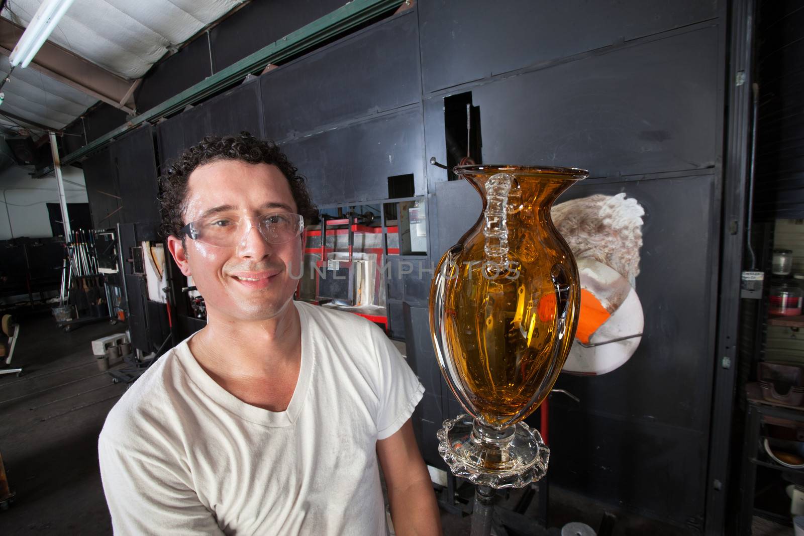 Handsome Hispanic man holding yellow vase on rod