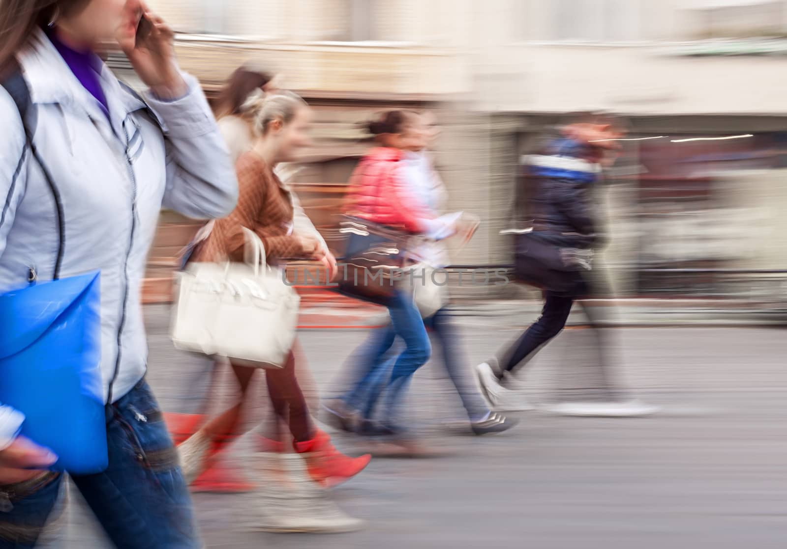 A group of young people going along the street. Intentional motion blur