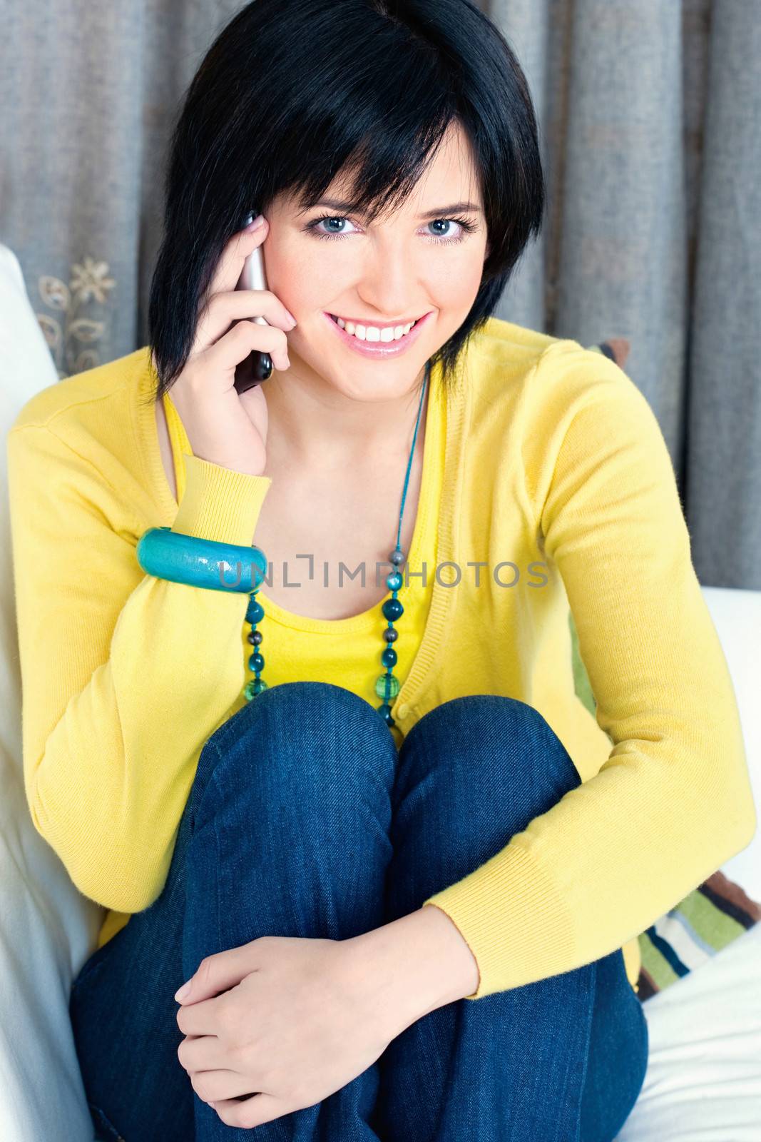 Pretty girl using mobile phone at home