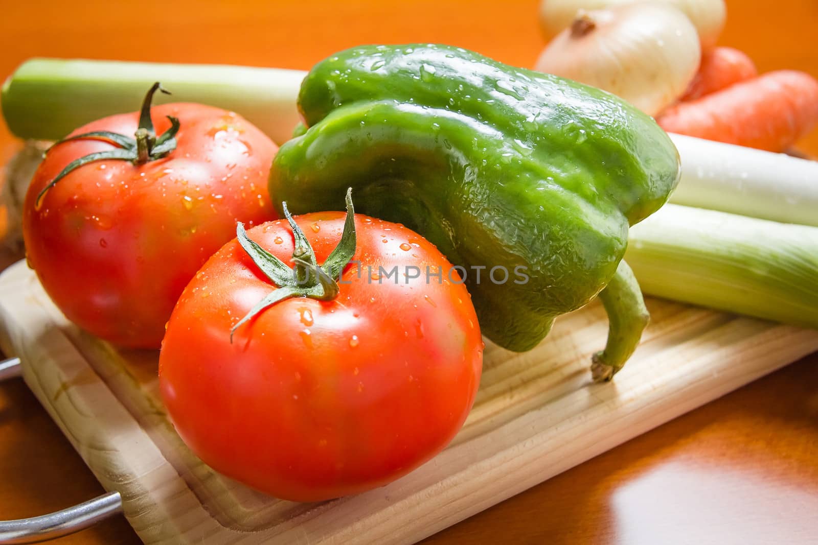 Fresh vegetables on cutting board in a wooden kitchen table