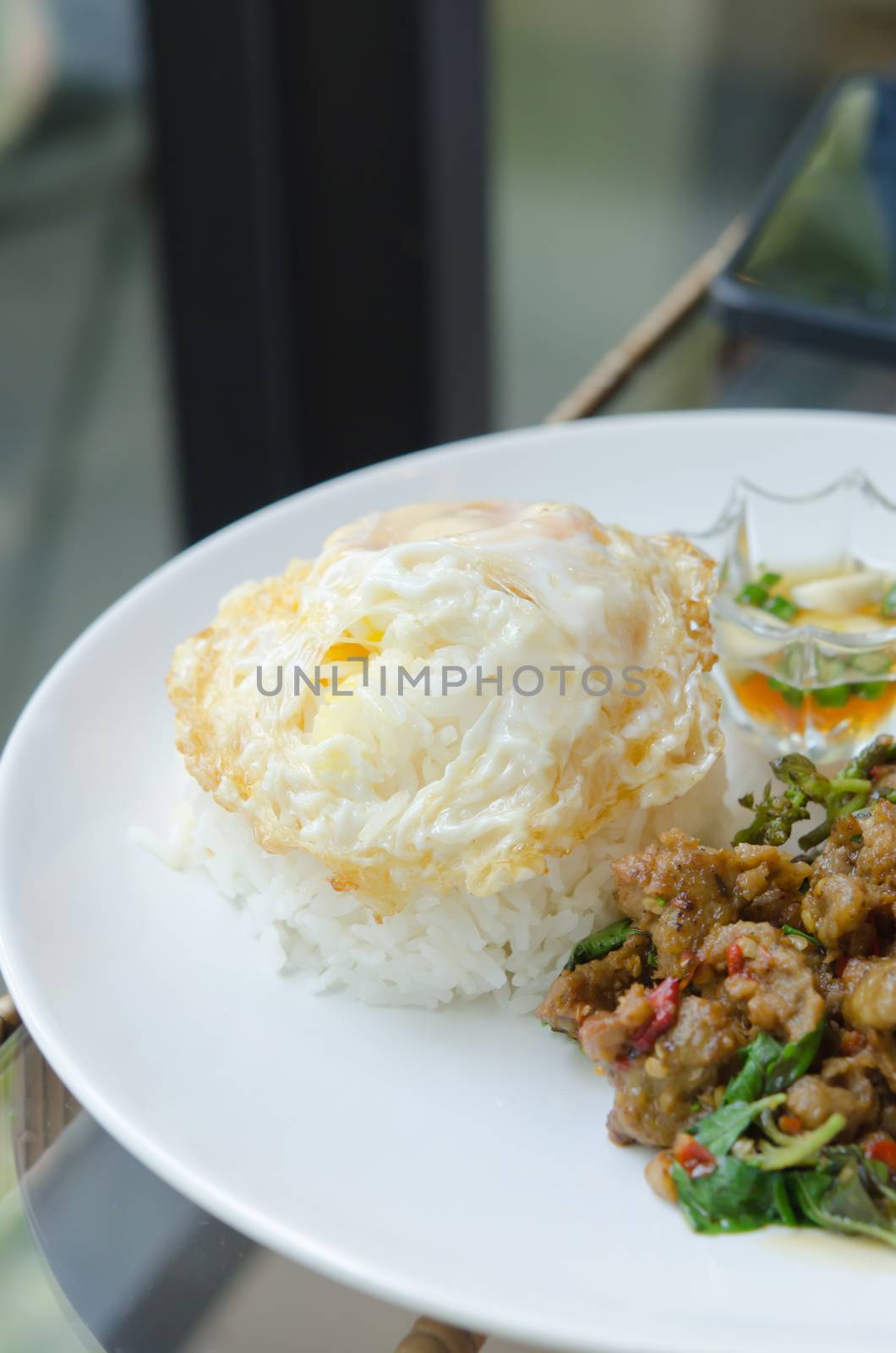 close up steamed rice and fried egg , served with  stir fried minced pork with chili , sweet basil on dish