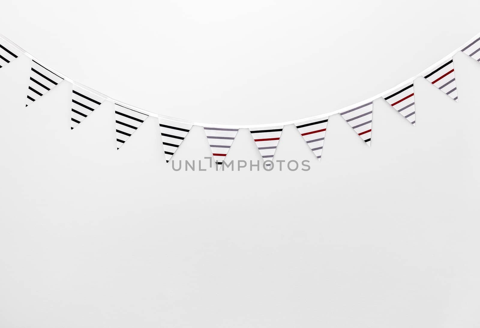 Striped bunting flags decorating an empty white wall.