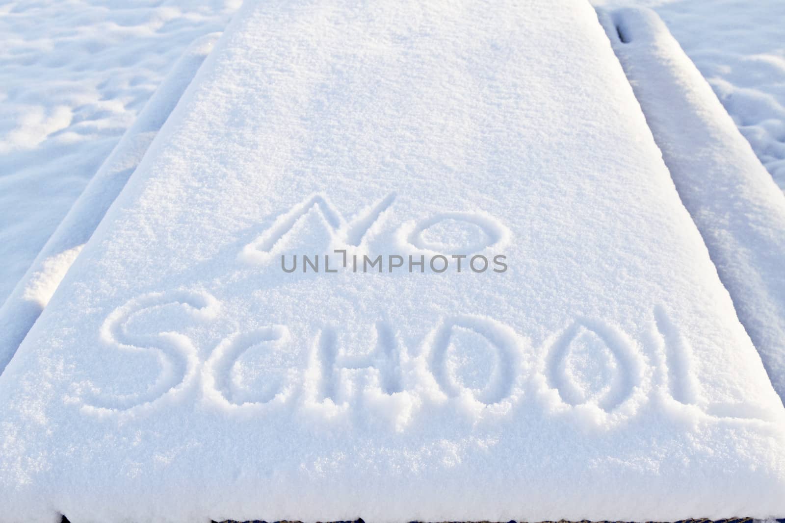 No School carefully printed in fresh snow indicates winter weather has closed local schools. 