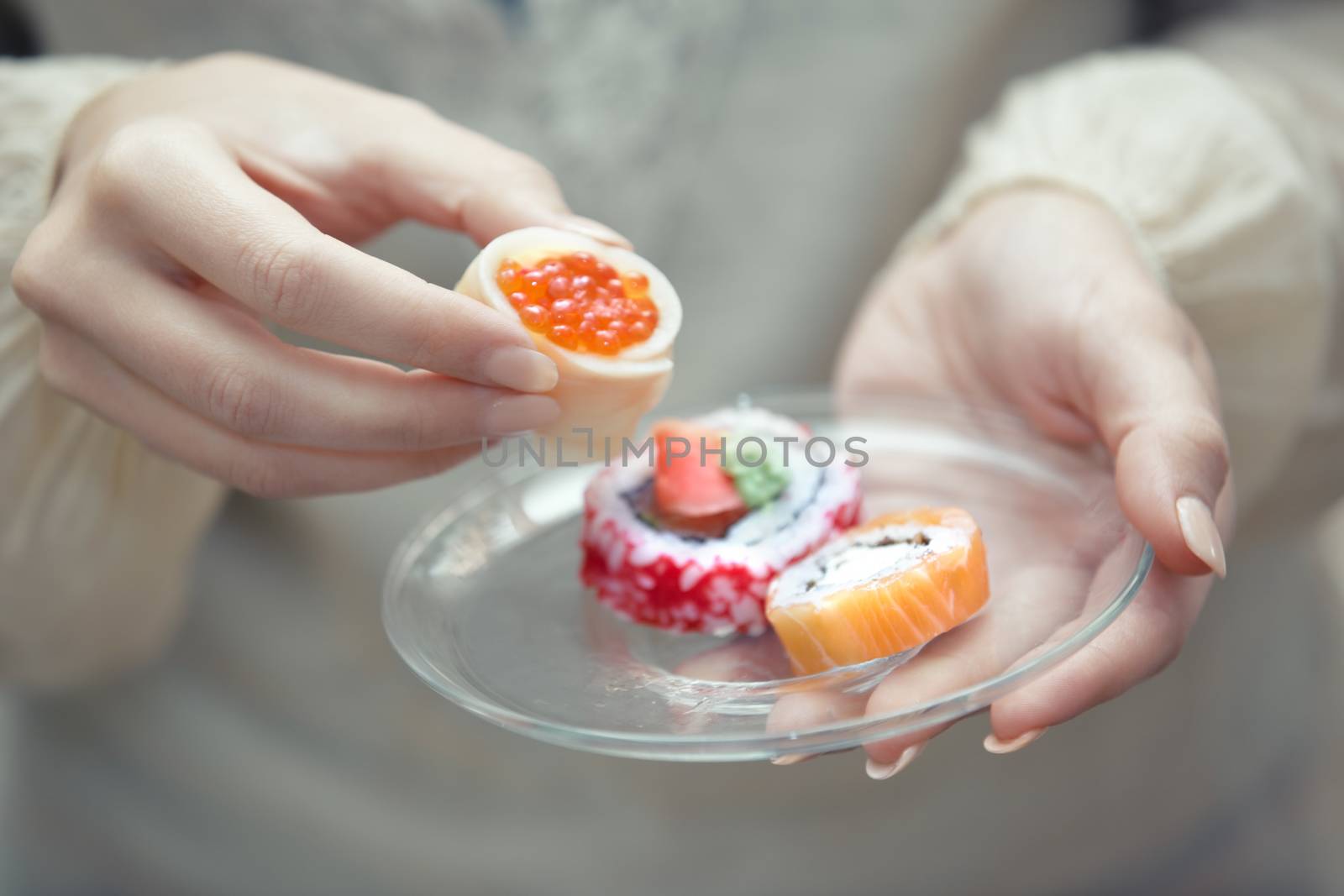 Human hands holding plate with sushi
