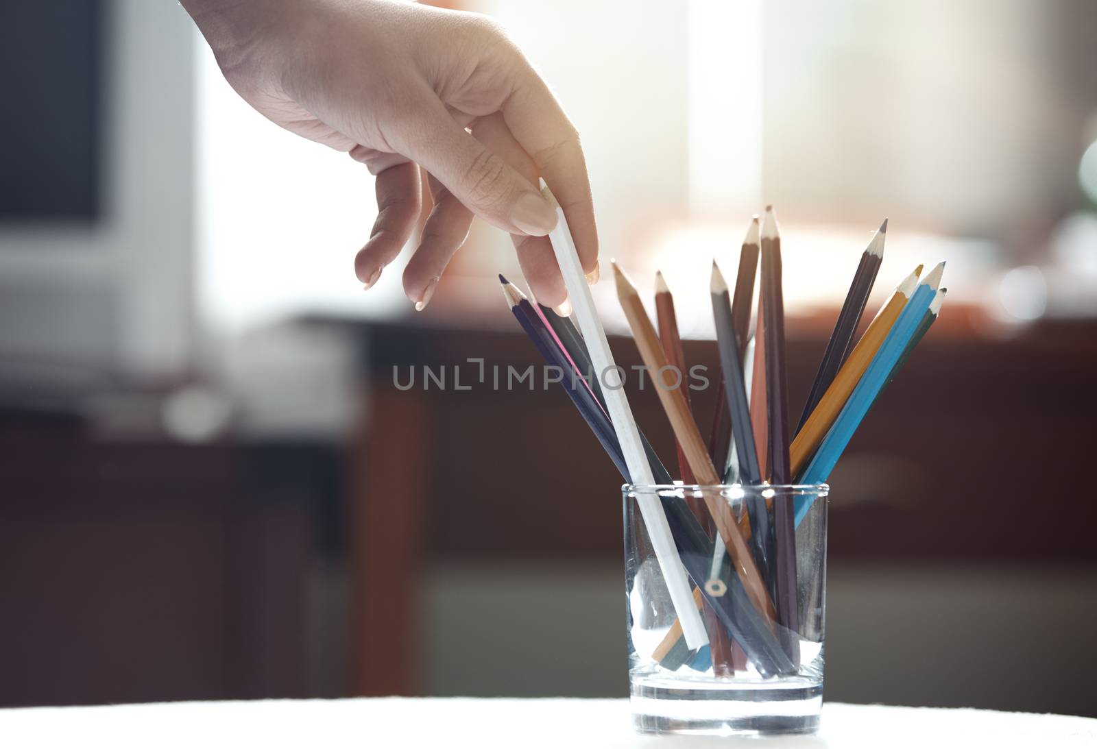 Human hand taking pencil in artist room