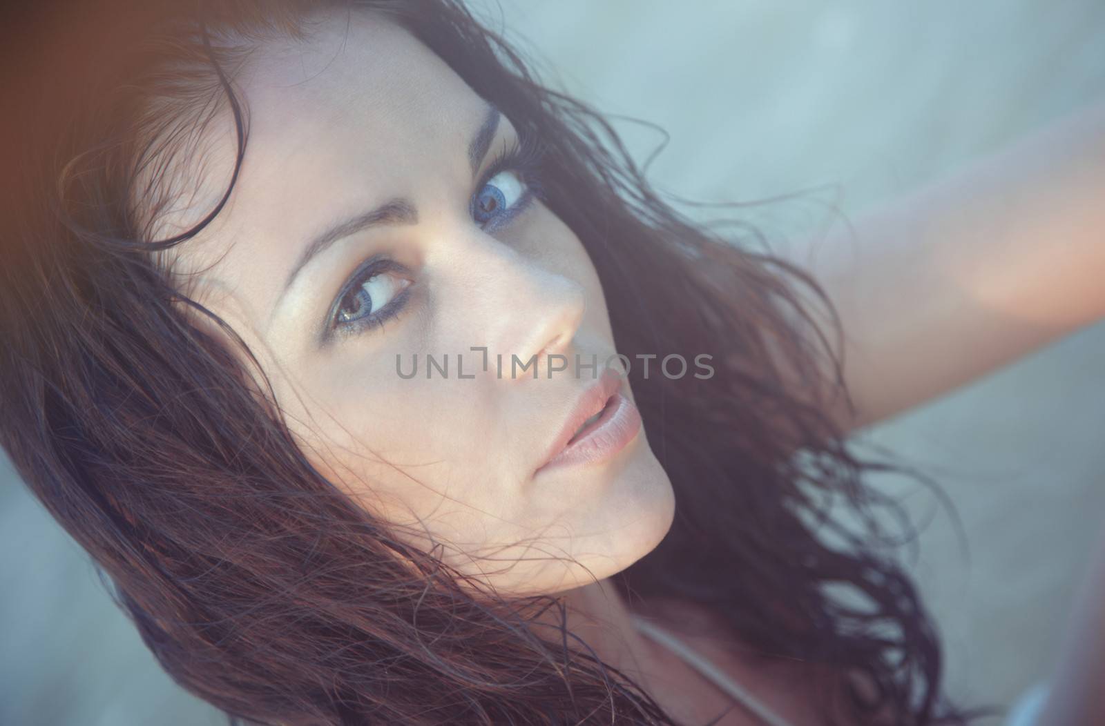 Pensive woman with wet hairs in the water. Natural light and colors