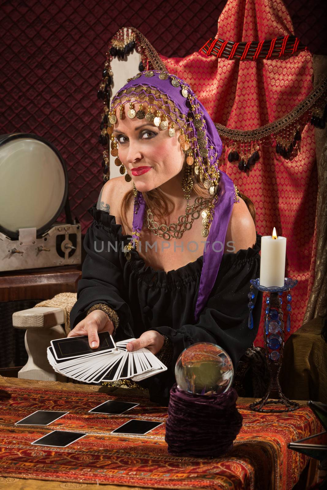 Beautiful Roma woman with crystal ball and tarot cards
