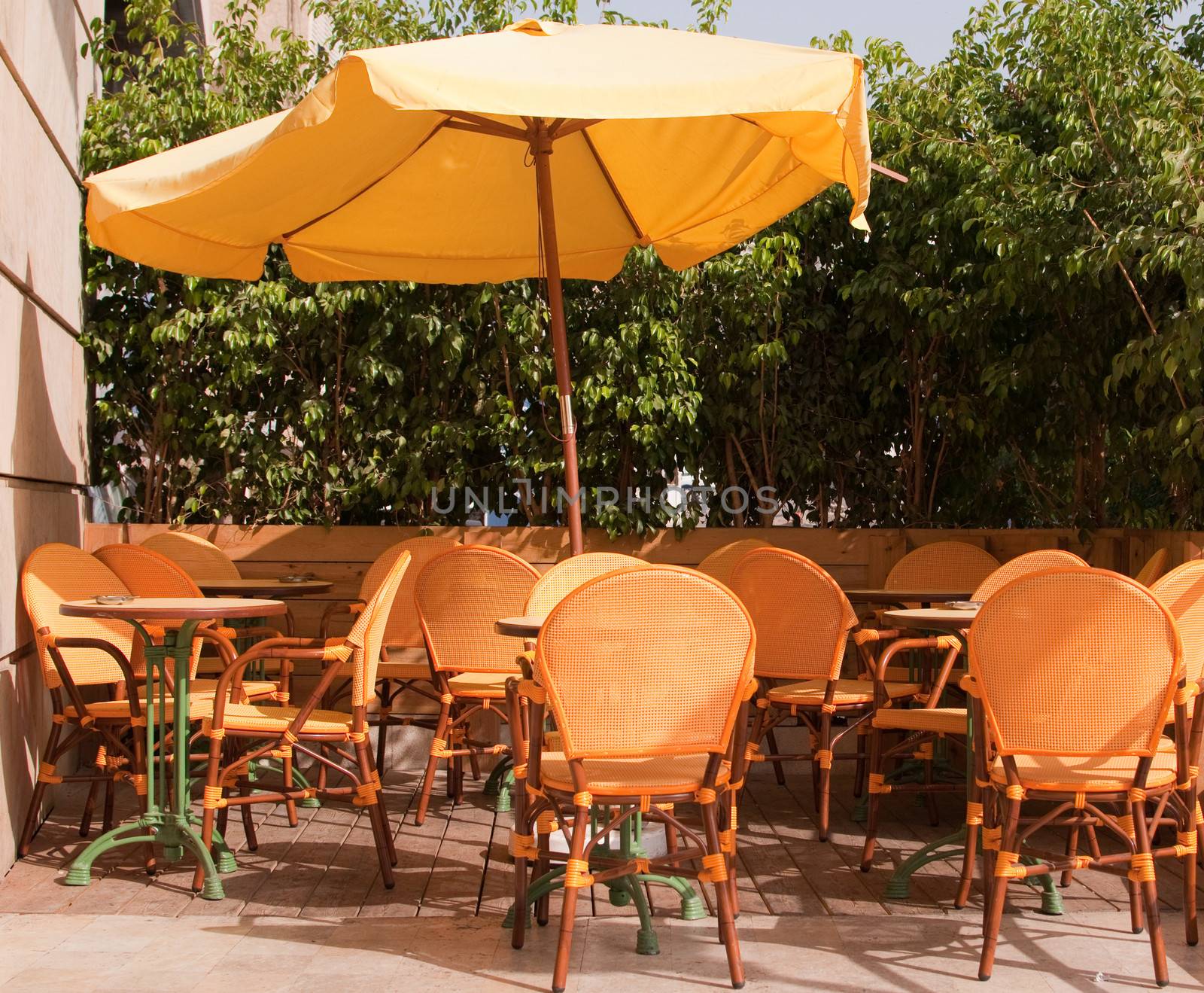 Yellow outdoor cafe with wicker chairs.