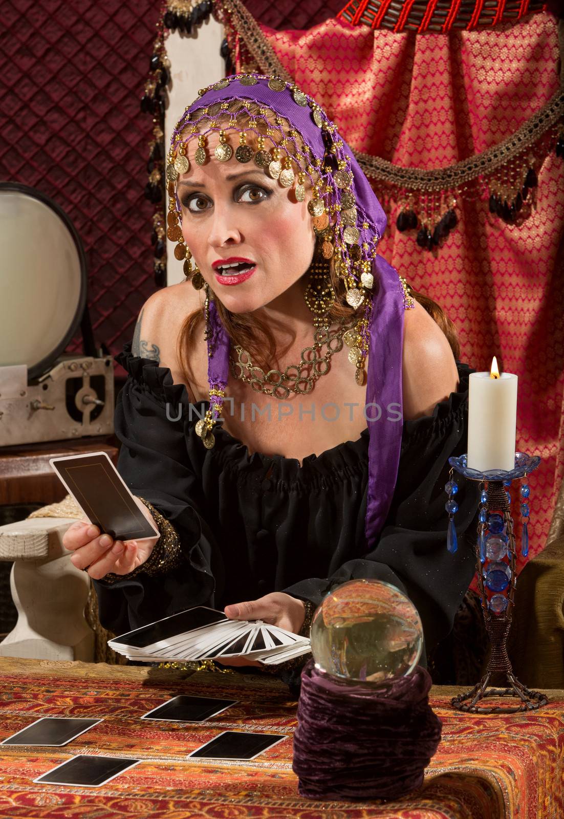 Nervous Caucasian female fortune teller with tarot cards