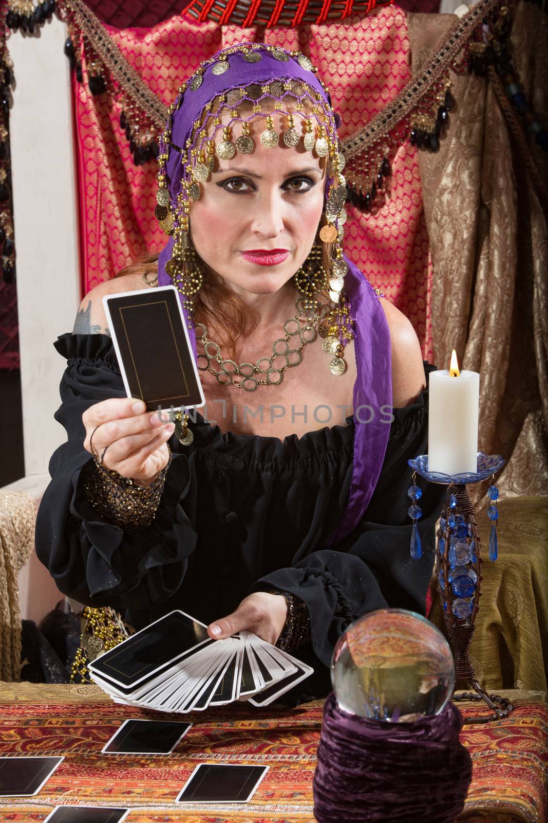 Pretty Romani woman dealing blank tarot cards