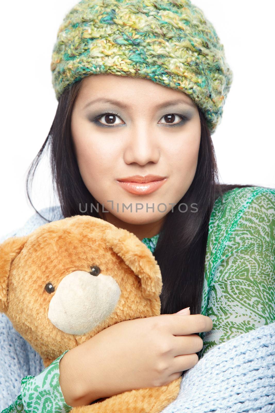 Smiling lady in stylish clothes with perfect makeup holding the toy on a white background