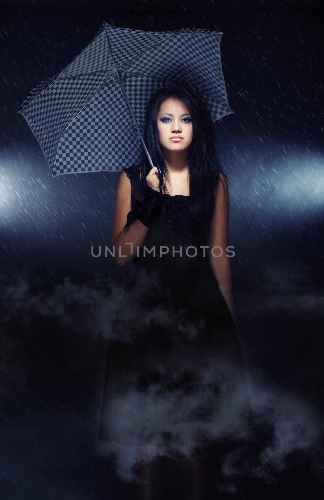 Elegant lady with umbrella standing under the rain