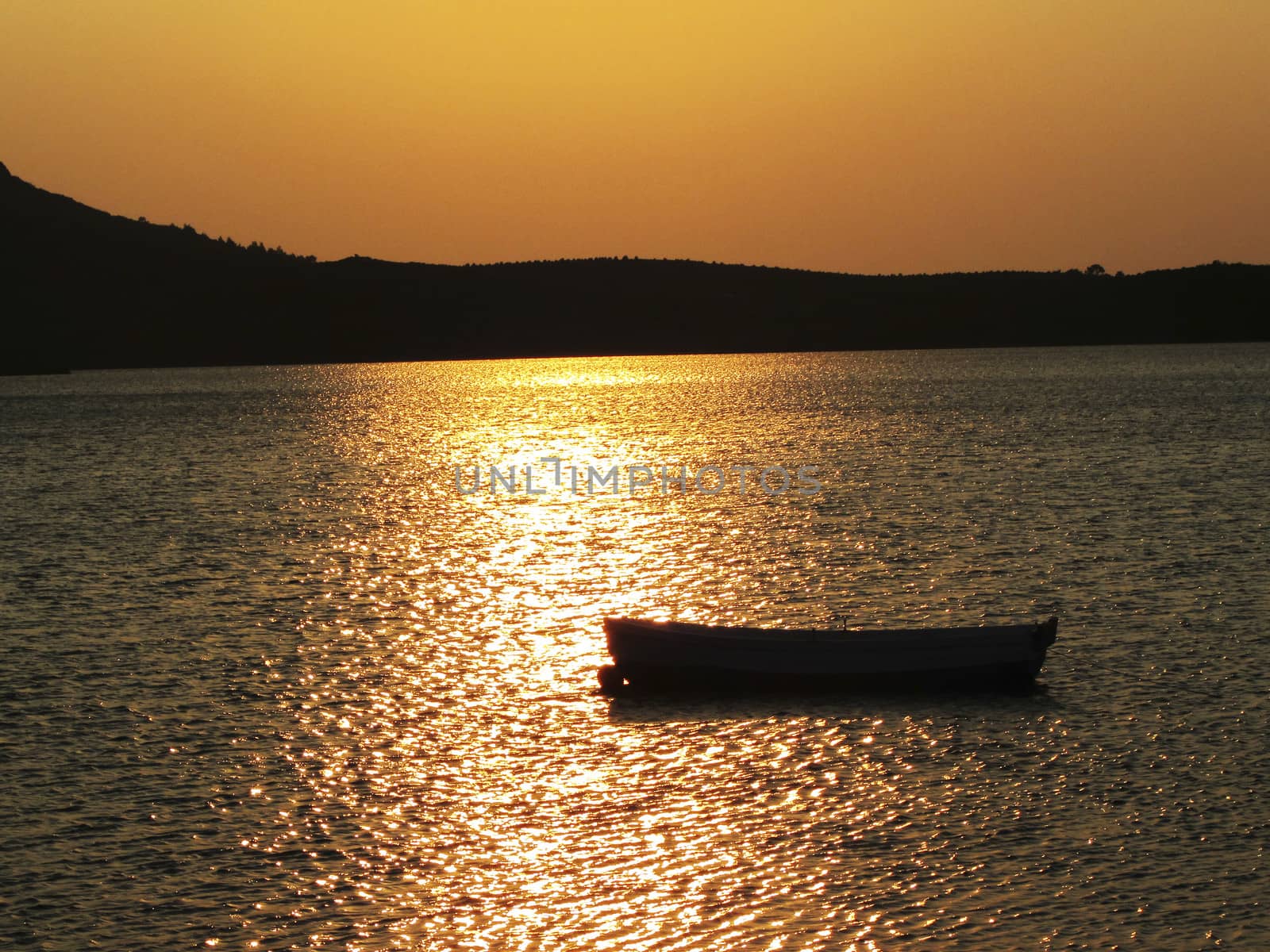 A small boat in front of a wonderful sunset