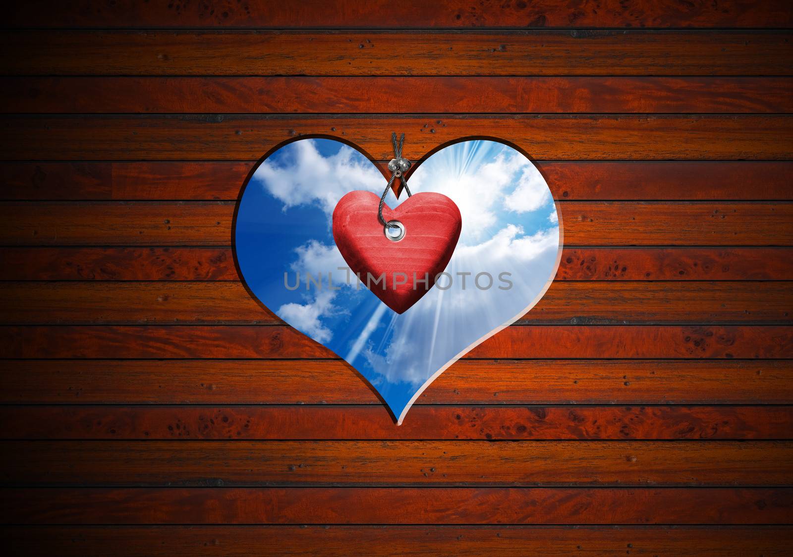 Brown wooden wall with a hole in the shape of heart with blue sky and red heart