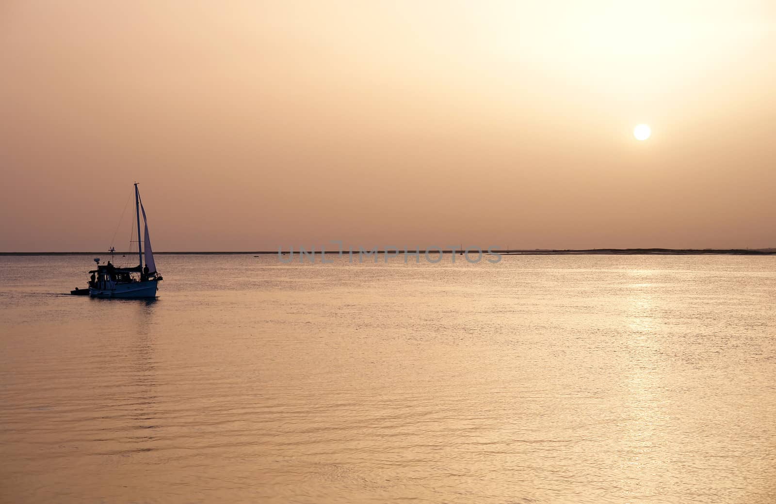 Recreation boat at sunset, in Ria Formosa, natural conservation region in Algarve, Portugal. 