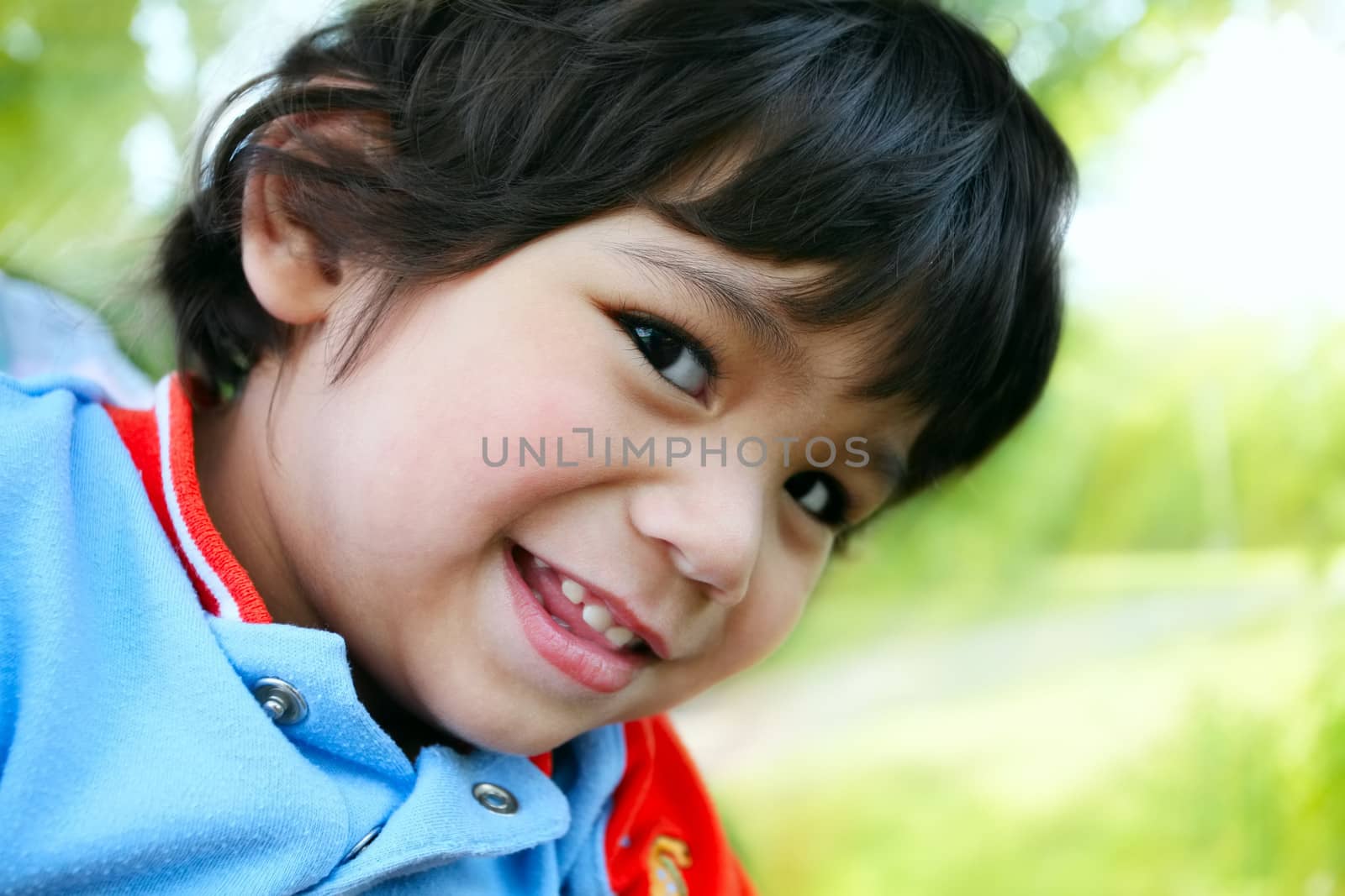Happy toddler boy smiling, looking sideways at camera by jarenwicklund