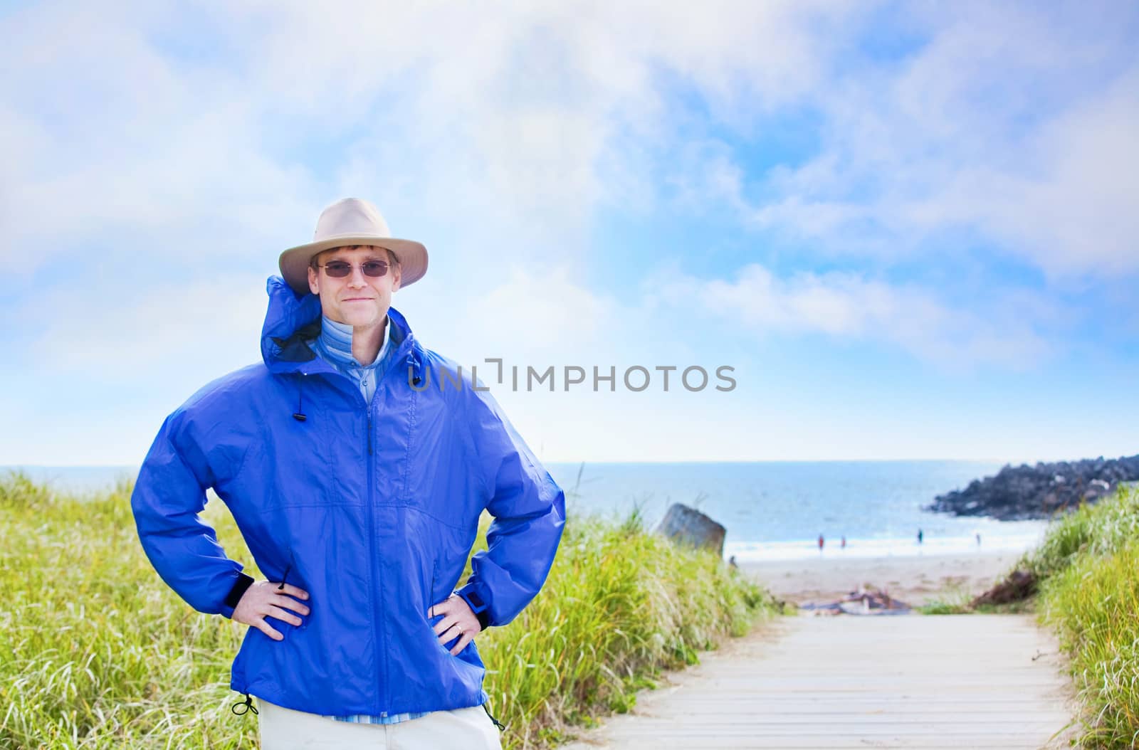 Caucasian man in forties wearing rain jacket by ocean shore by jarenwicklund