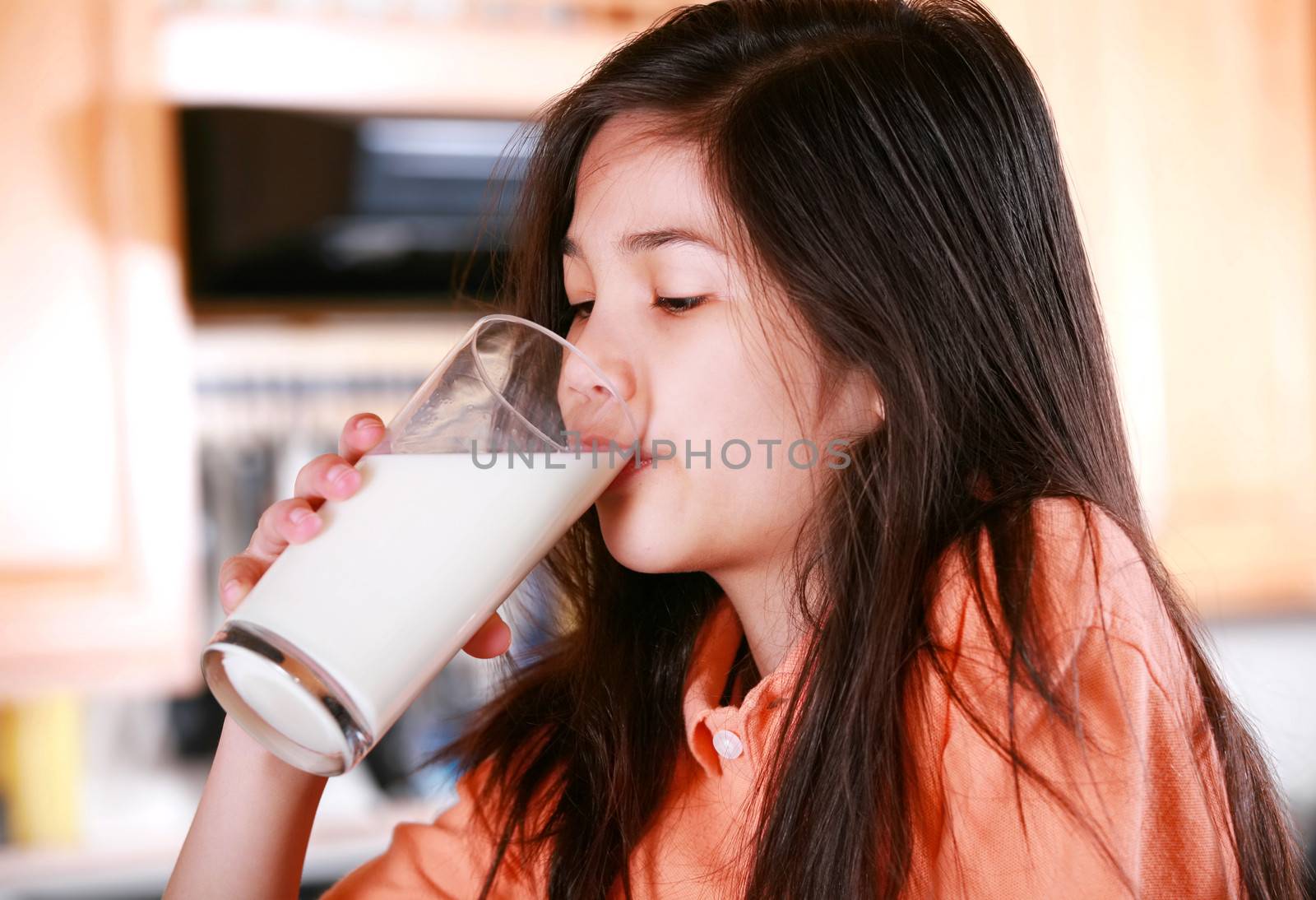 Beautiful young biracial girl drinking milk