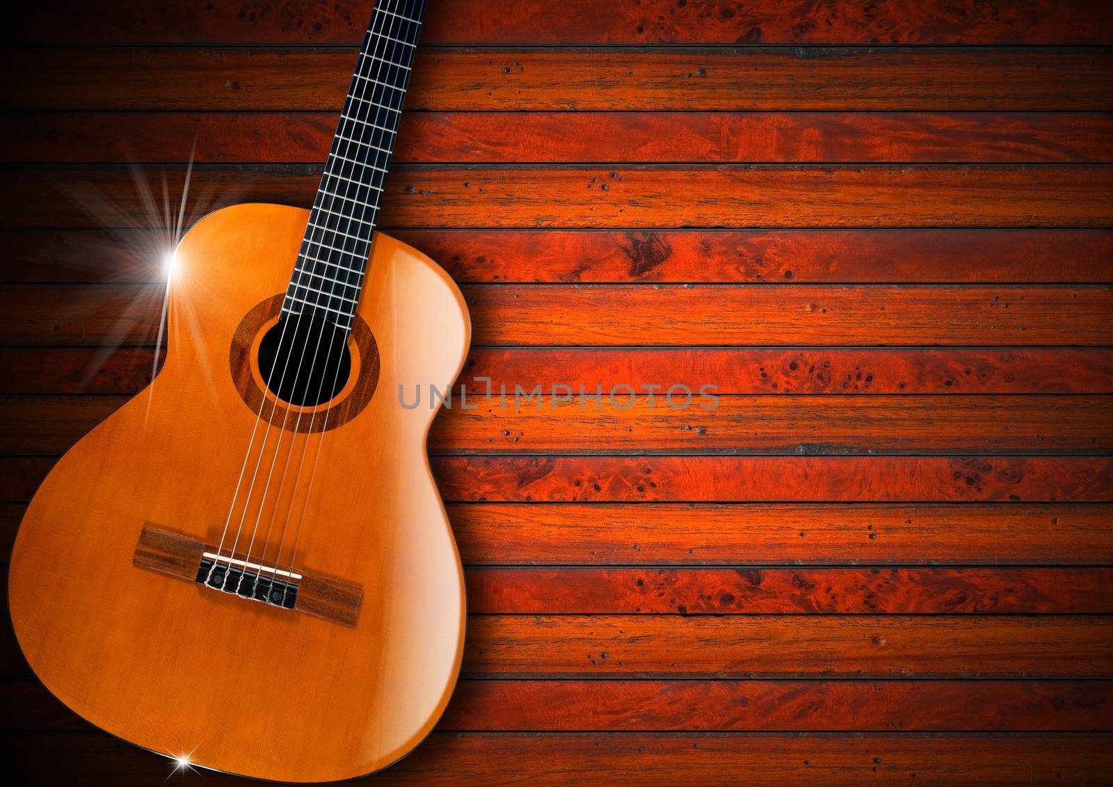 Acoustic brown guitar against a rustic wood background 