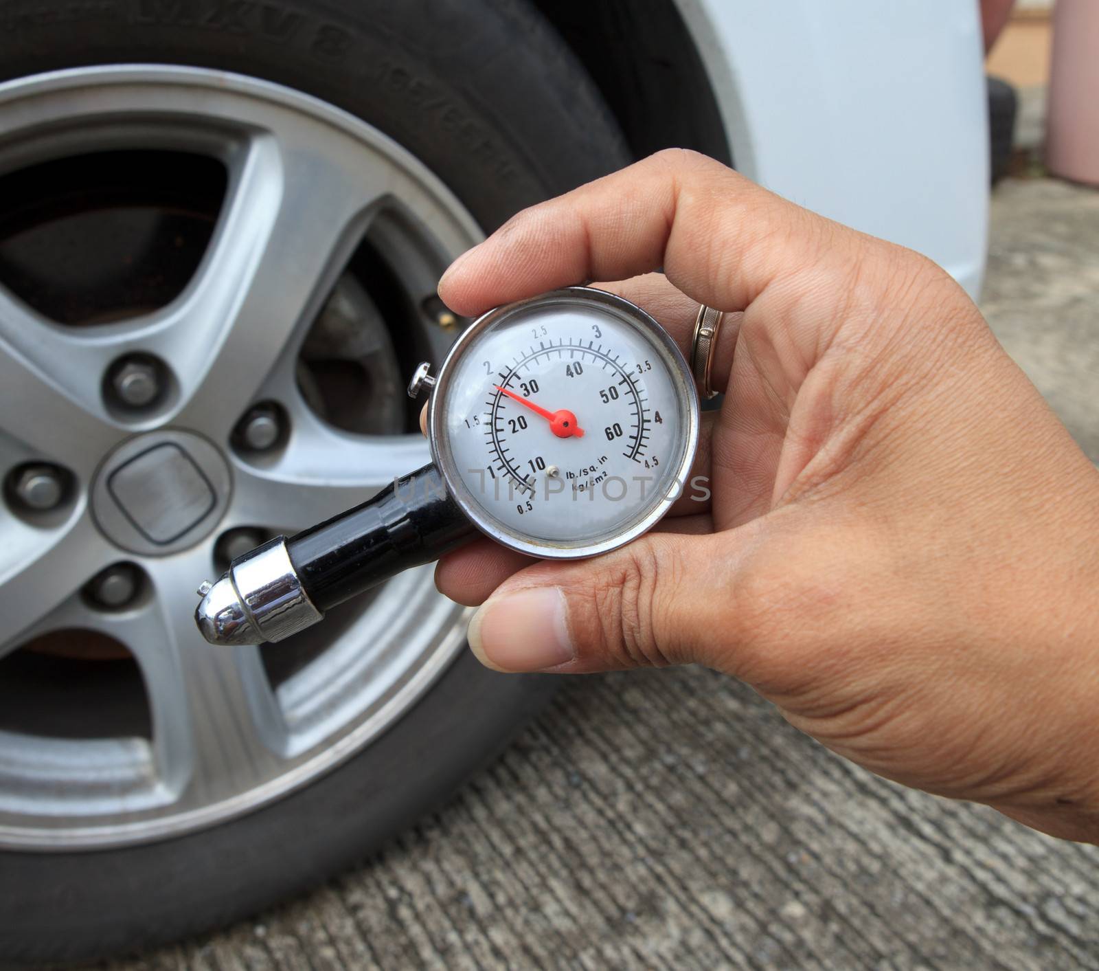 checking tire air pressure with meter  gauge before traveling by khunaspix