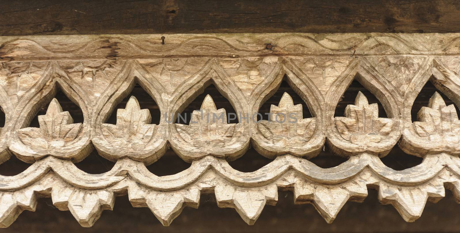 Carved wooden lattice work with Thai style pattern art in Thailand.