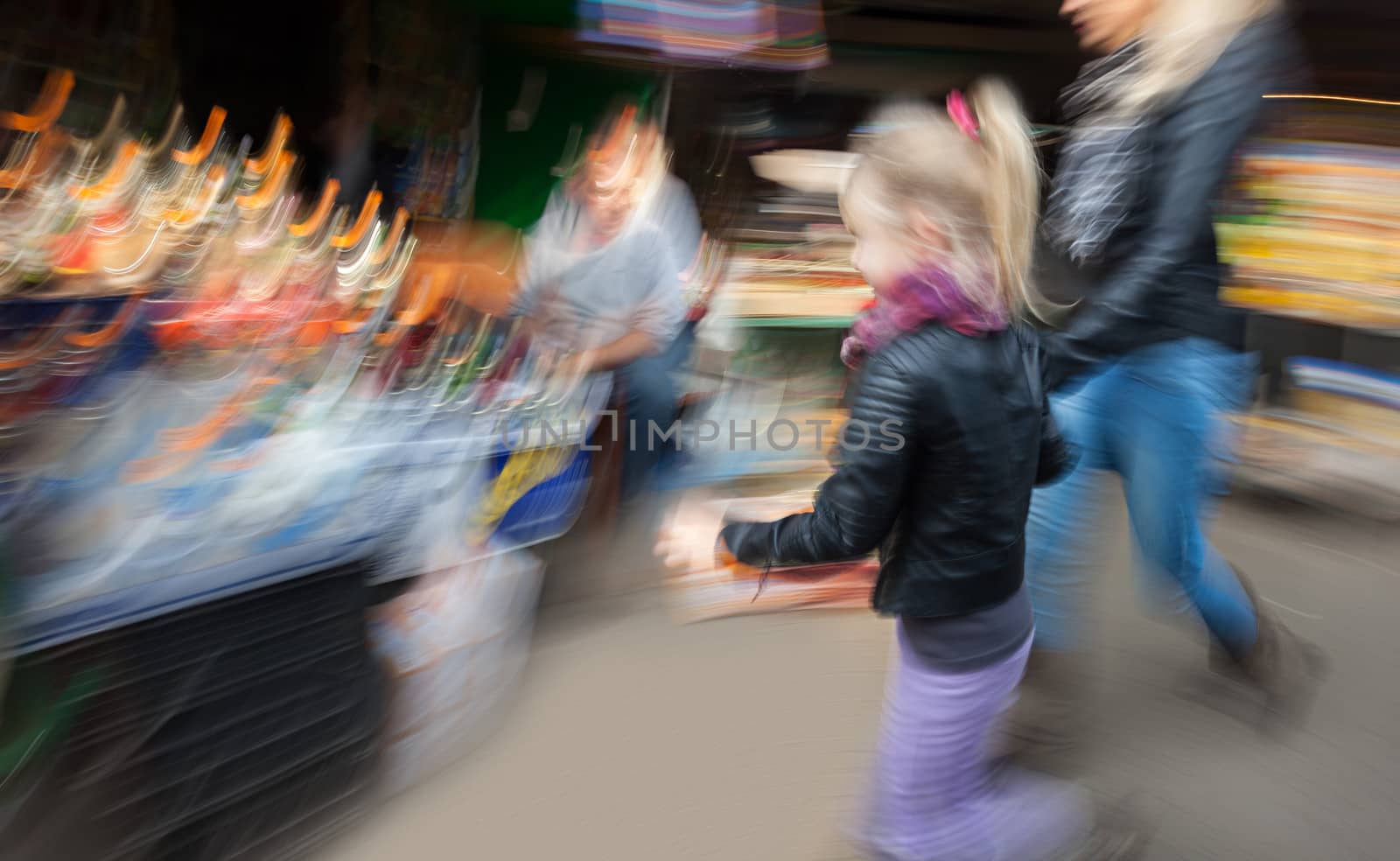 Mom and daughter purchased goods in the urban market. Intentional motion blur