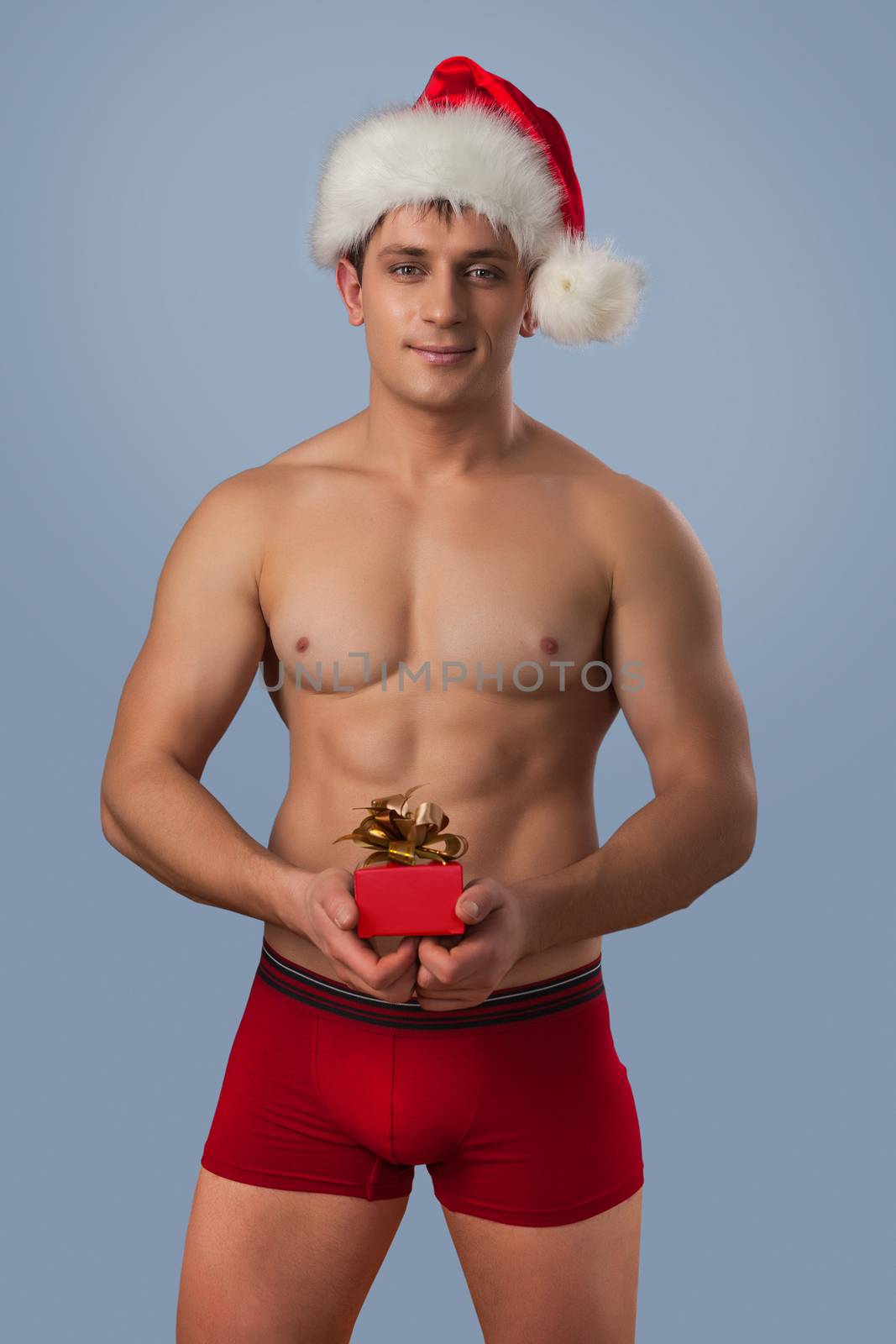 a muscular naked man in santa cup