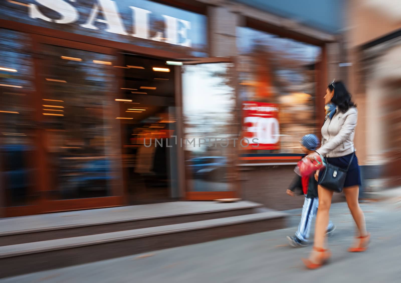 Mother and son shopping in mall. Intentional motion blur