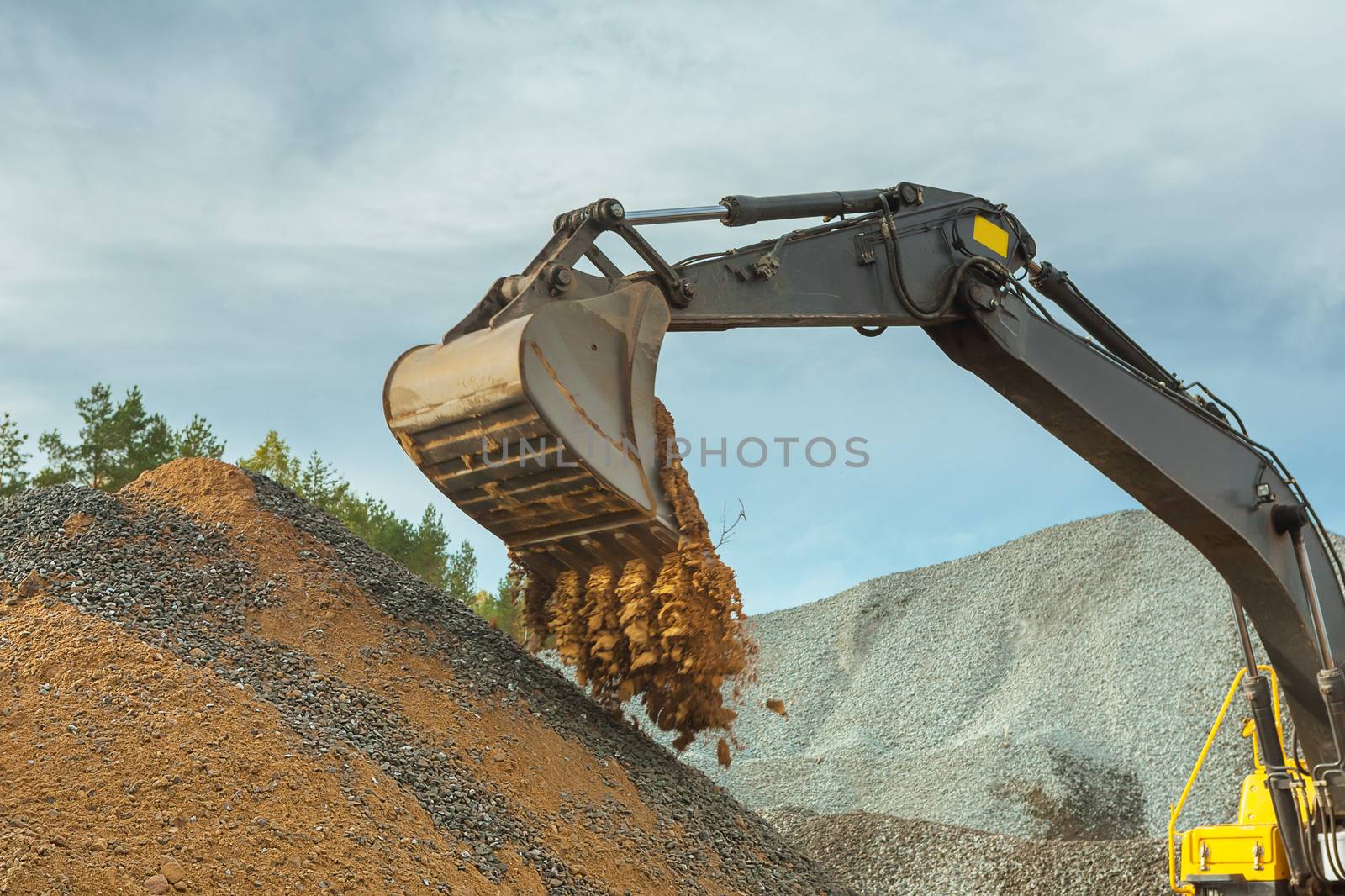 sand pouring from scoop of excavator by mihalec