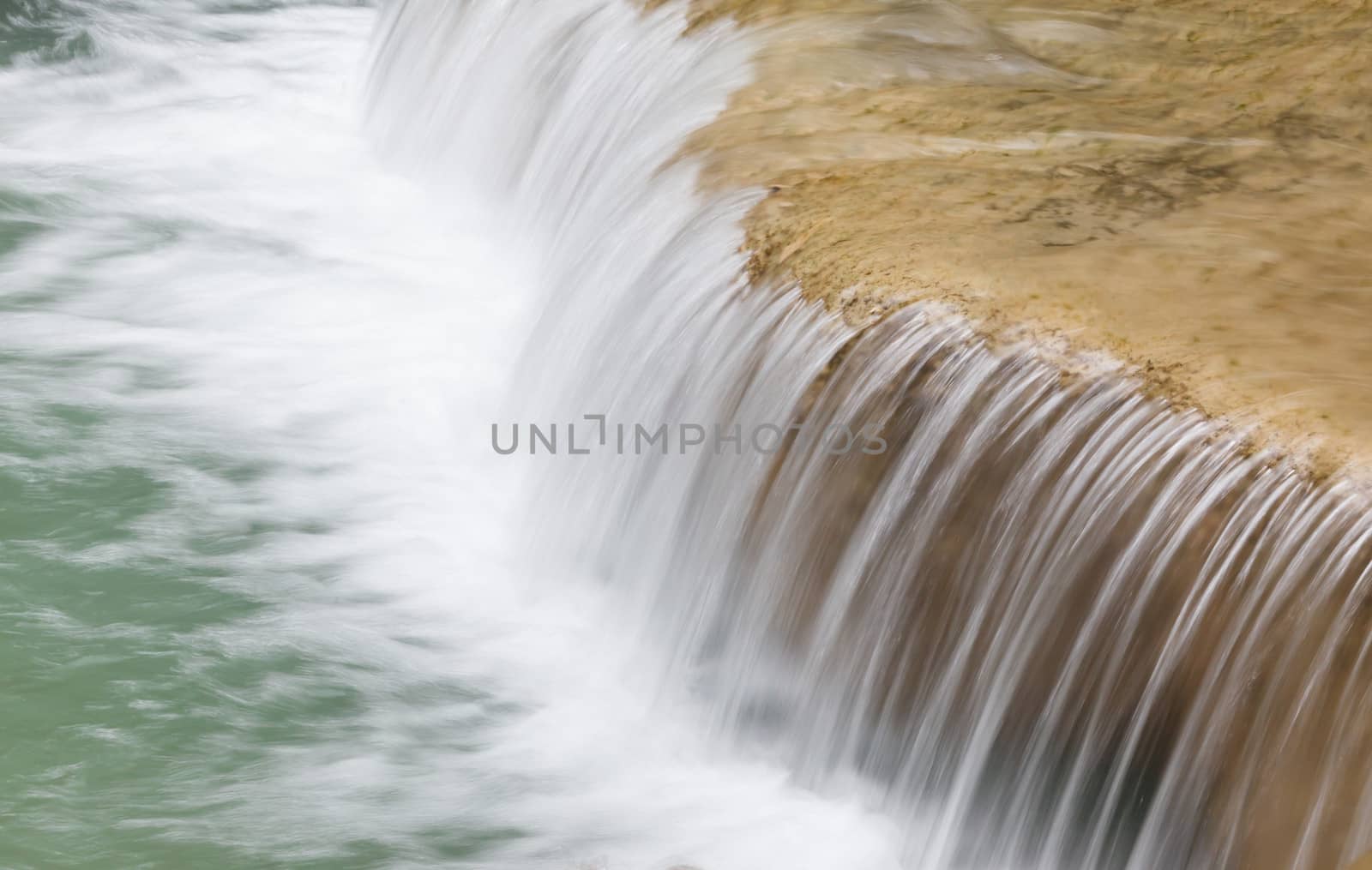 water flowing down from the rocks by panyajampatong