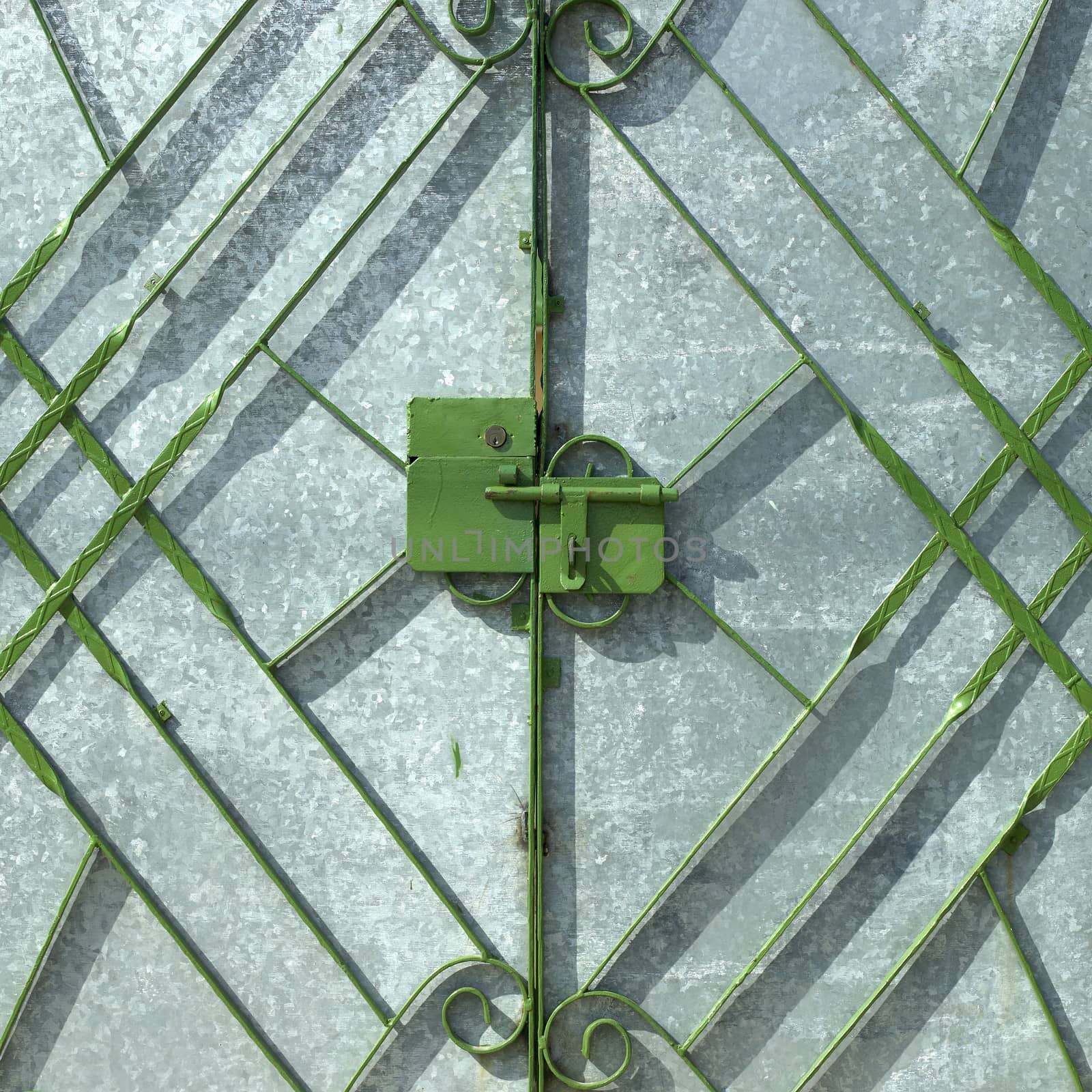 Green metal gate in fron of silver door
