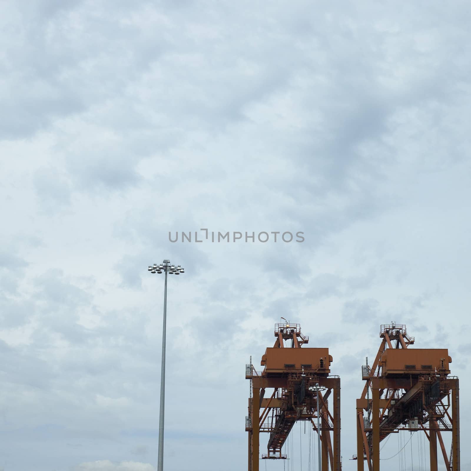 large orange port cranes and cloudy sky