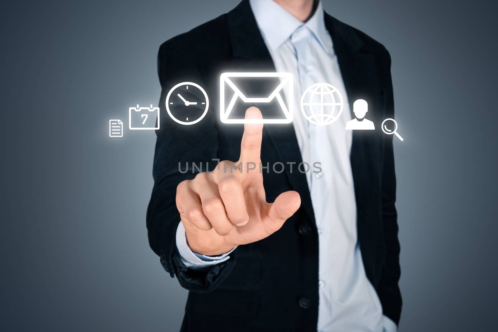 Portrait of young handsome businessman touching futuristic menu interface with various digital icons. Isolated on dark background