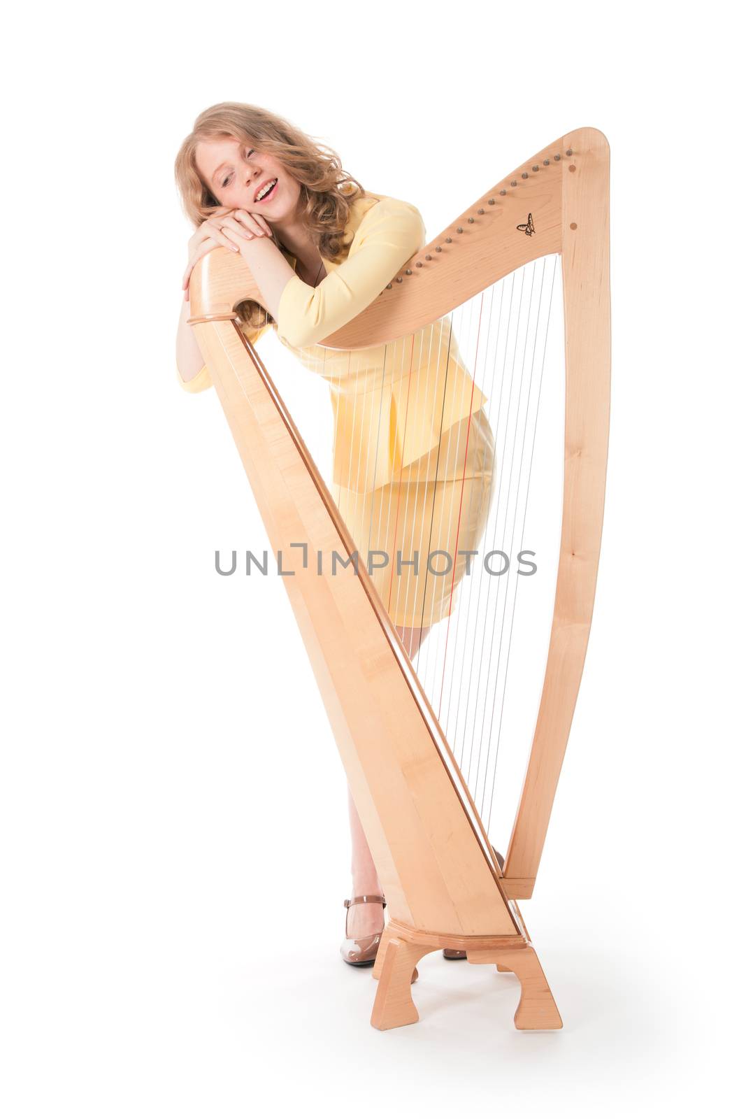young woman in sexy yellow mini dress standing behind harp
