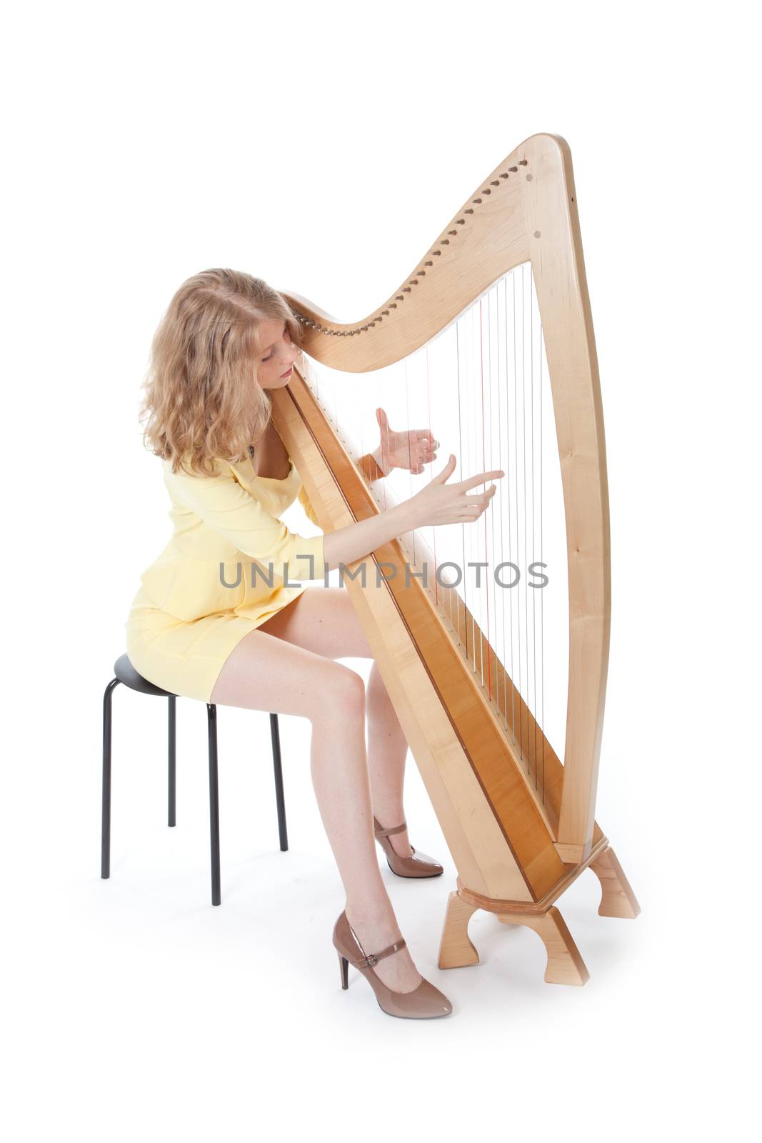 young woman in sexy yellow mini dress playing the harp