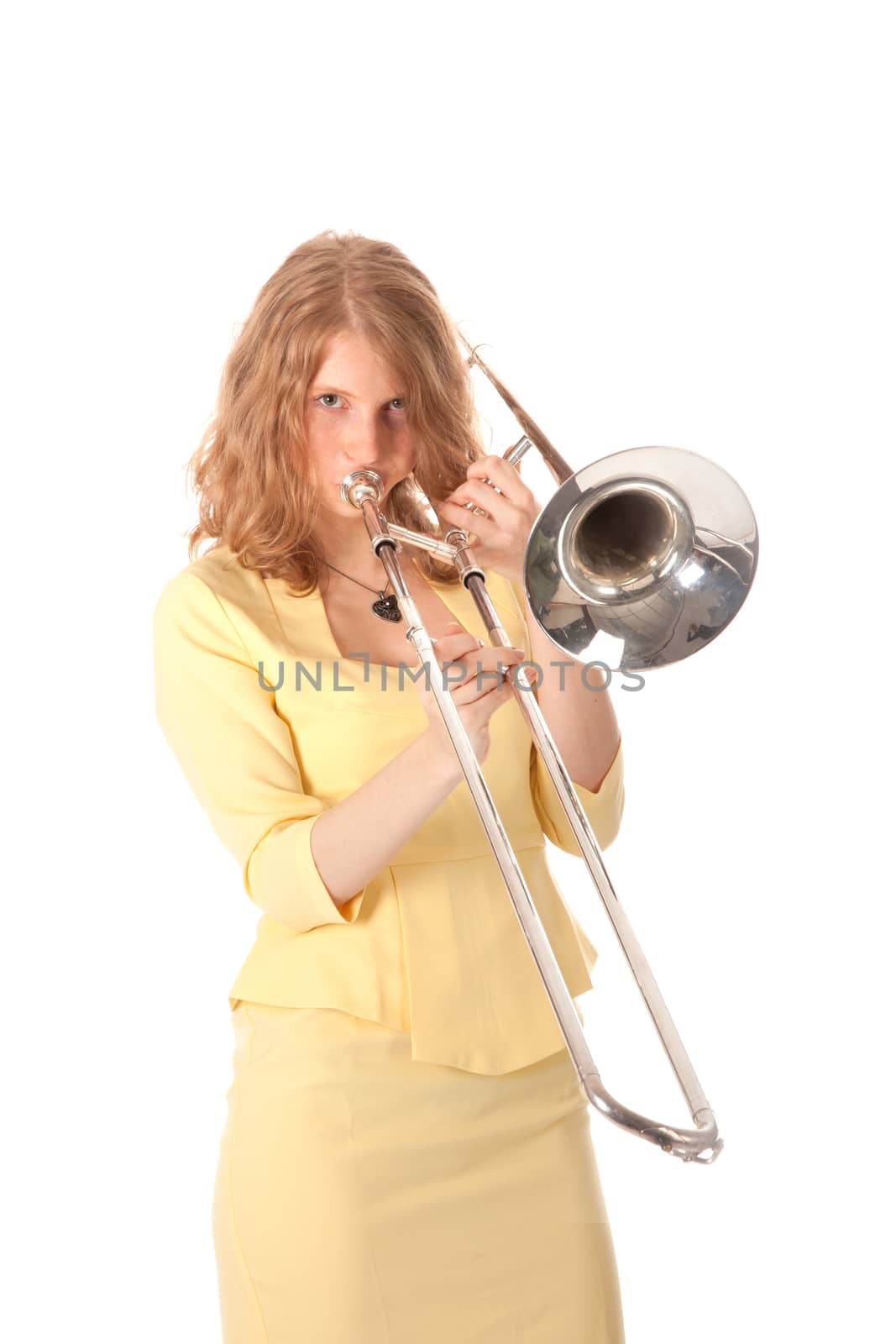 young woman in yellow holding trombone and white background