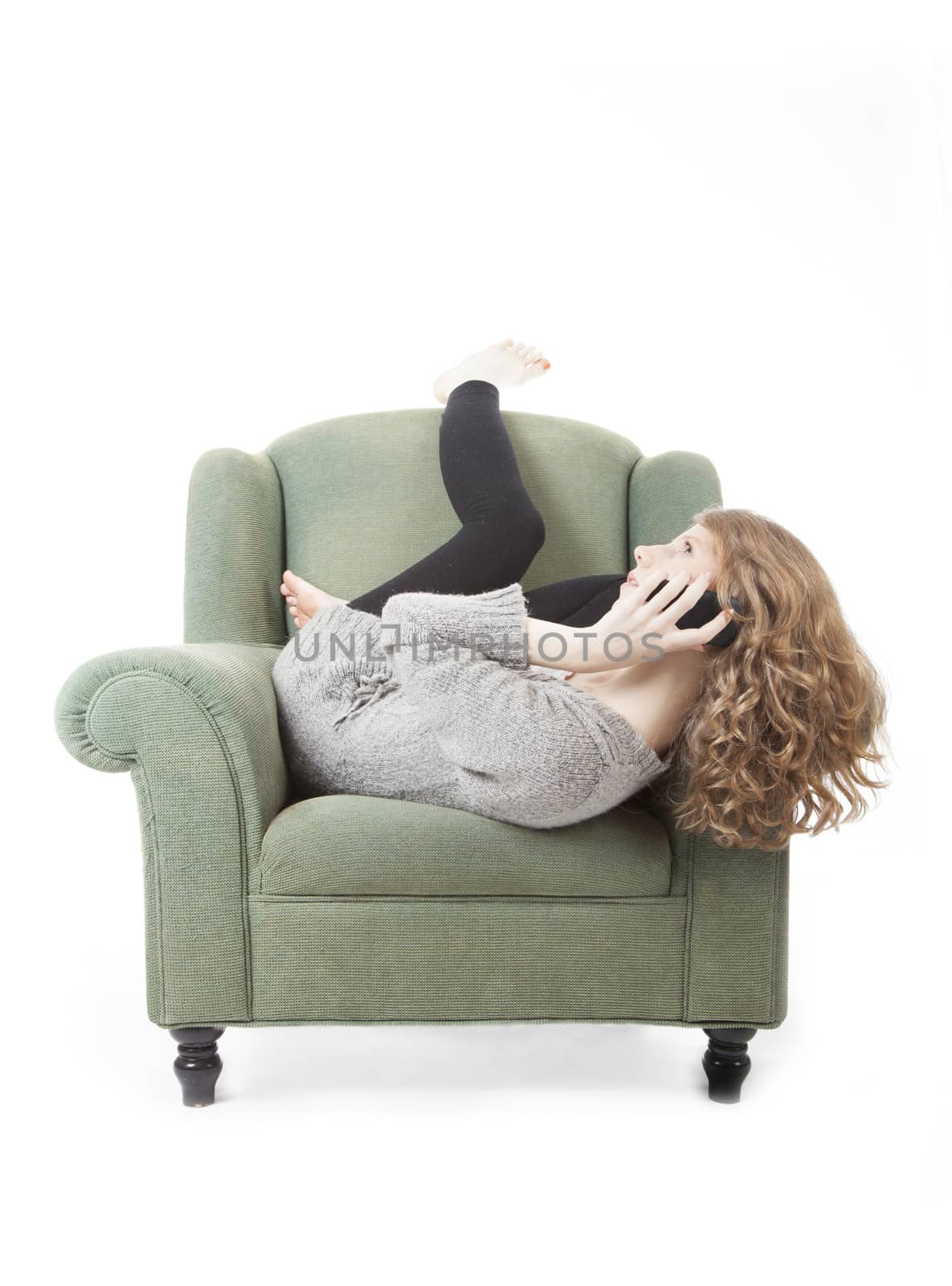 young pretty woman on the phone in armchair against white background